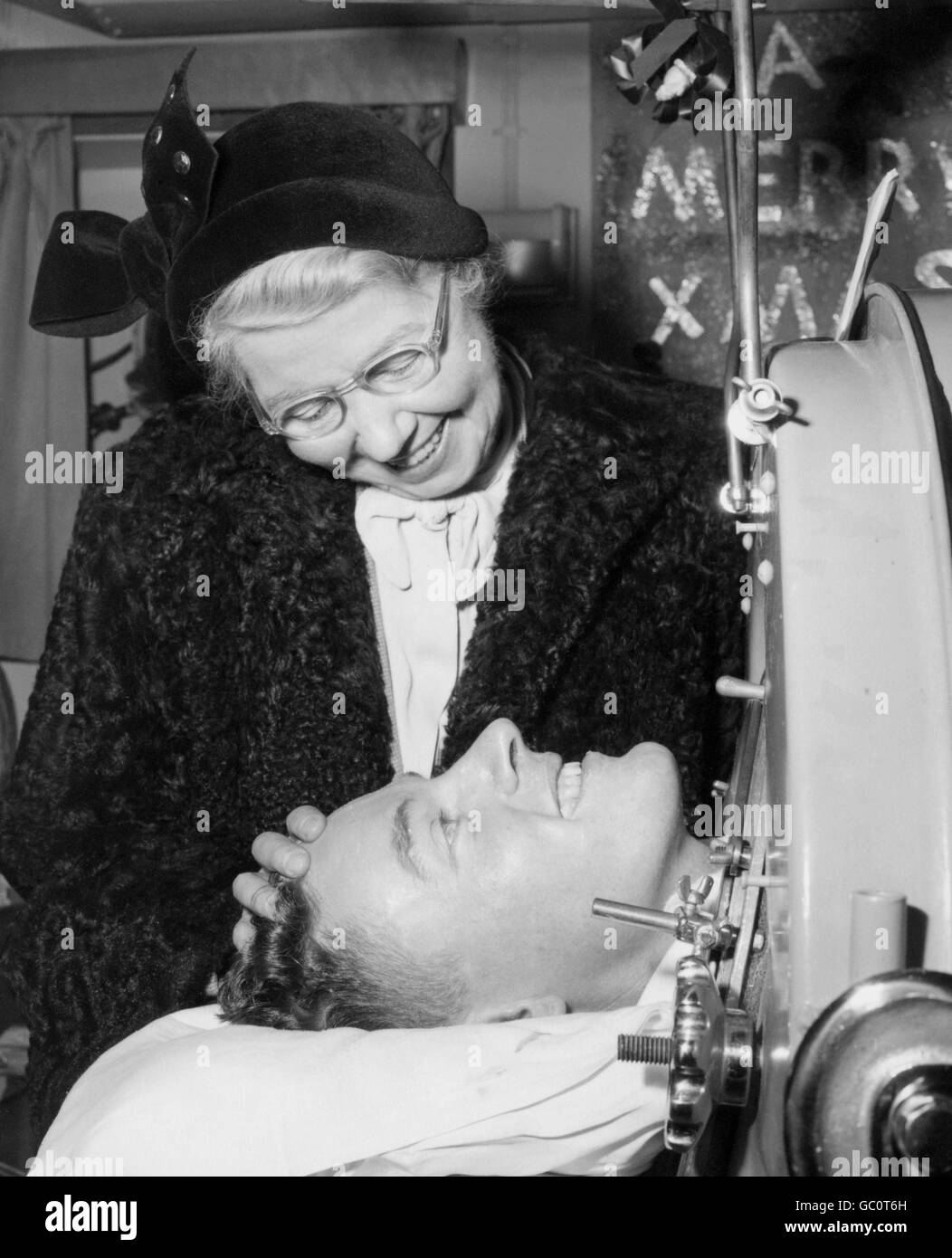 John Taylor, a 28-year-old polio victim, is greeted by his mother when he arrived in an iron lung aboard the liner Rangitane at Southampton from the Panama Canal zone. John was stricken with polio when working in an oil field in Ecuador. Stock Photo