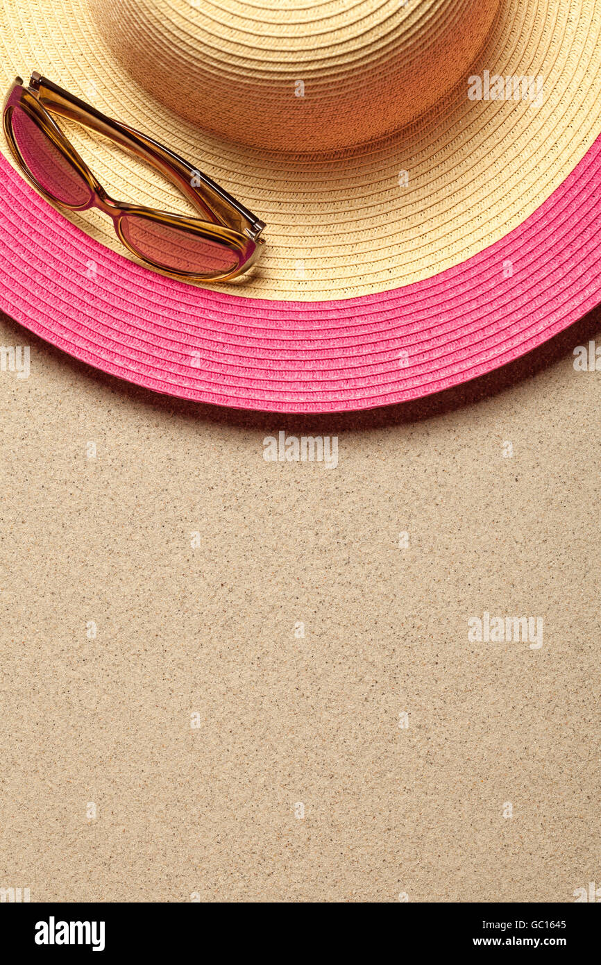 Summer concept with hat and sunglasses on sandy beach background. Top ...