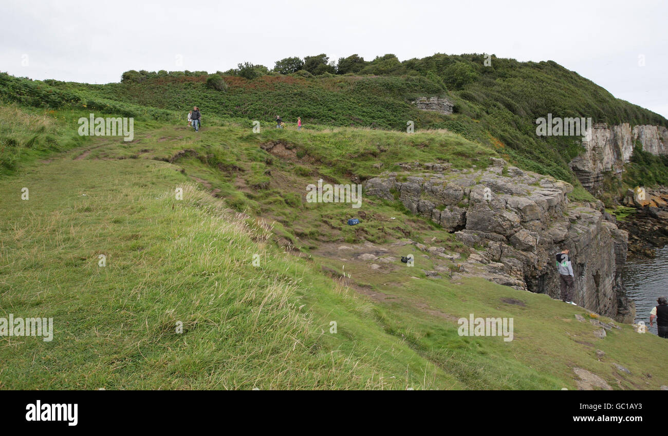 A general view of the scene in Benllech, Anglesey, where 11-year-old Paige Dean cheated death after jumping from her grandfather's car before it fell 50ft off a cliff edge and landed in the sea. The car travelled from top left of the picture and went over the cliff to the left of where the man is standing. Stock Photo