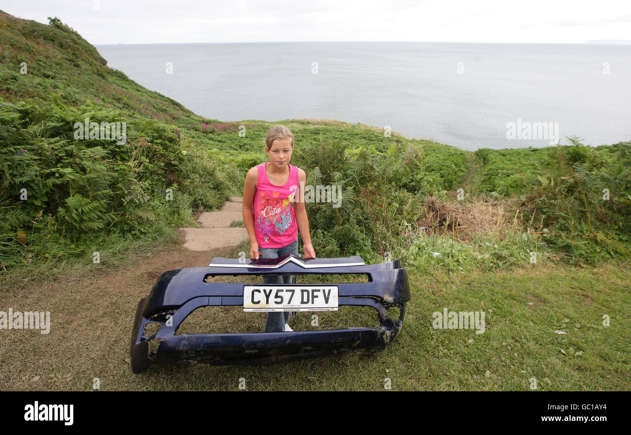 11-year-old Paige Dean - shown holding a piece of the car which came off before entering the sea - who cheated death after jumping from her grandfather's car before it fell 50ft off a cliff edge and landed in the sea in Benllech, Anglesey. Stock Photo