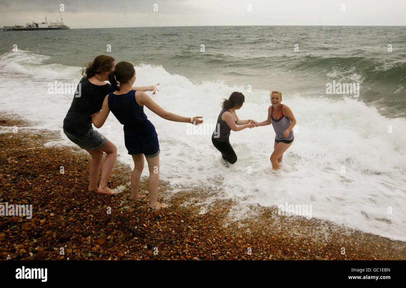 Alice Keable and Yvonne Grout (right) go for a swim at Brighton beach in Brighton, East Sussex, as the unpredictable summer weather continues with torrential rain spreading across the north of the UK, and the south enjoying a prolonged warm spell. Stock Photo