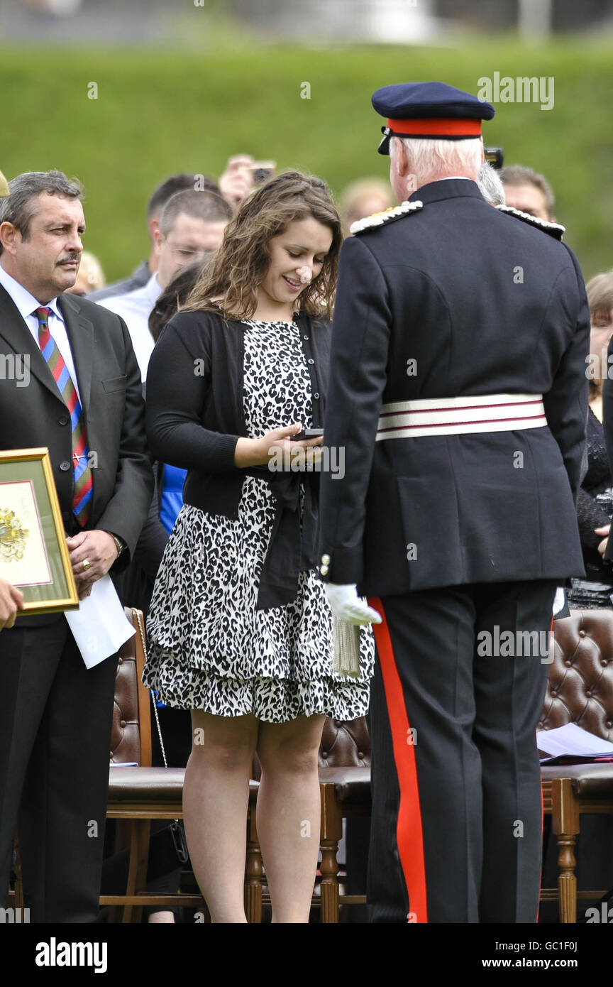 Danielle Harkett, the wife of Lance Corporal Christopher Harkett, 22, who was killed in a blast near Musa Qala, in Northern Helmand, on March 14, receives the Elizabeth Cross during an Order of Service as troops from Charlie Company, 2nd Battalion The Royal Welsh, paid tribute to her husband in a remembrance service at Cardiff Castle after marching through the city. Stock Photo