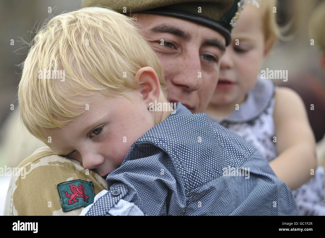 Lance Corporal David D'Angelo gets a cuddle from his three-year-old son Rhys, as soldiers from Charlie Company, 2nd Battalion The Royal Welsh, form up during a remembrance service at Cardiff Castle in memory of Lance Corporal Christopher Harkett, 22, who was killed in a blast near Musa Qala, in Northern Helmand, on March 14. Stock Photo