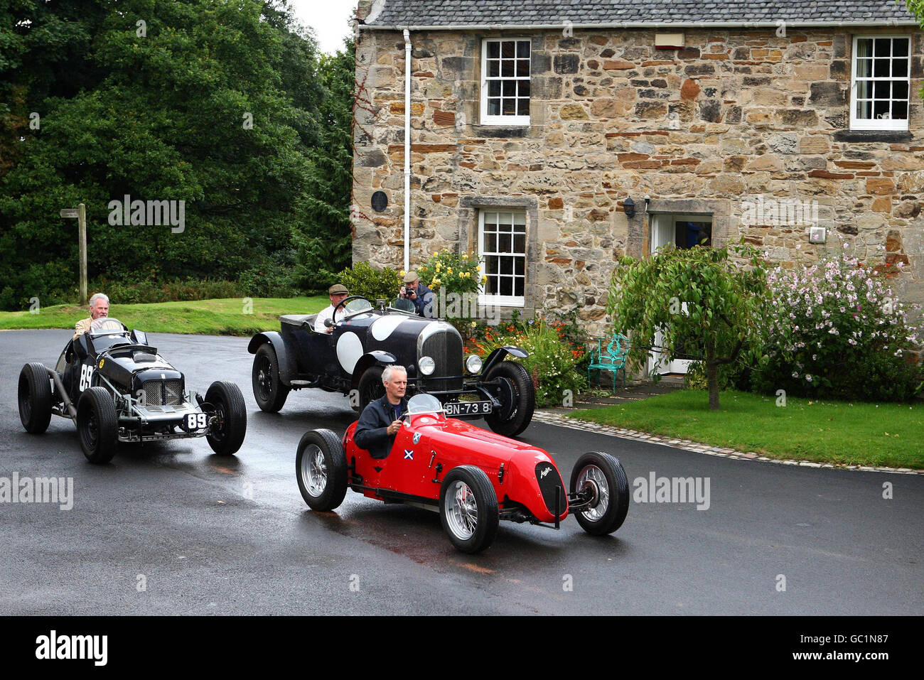 Three classic racing cars, a 1924 Bentley driven by Jock Mackinnon (rear right), a 1937 Austin 7 special driven by Steve Smith (front) and a 1953 Fairley Mercury driven by Alex brown (rear left), race past Duchess Anne Cottages on the Kinneil Estate at a preview of the forthcoming Bo'ness Speed Hill Climb being held there on Saturday 12 and Sunday 13th September. More than 120 classic cars and motorbikes from across the Uk will be blistering up Scotland's oldest permanent racetrack. Stock Photo