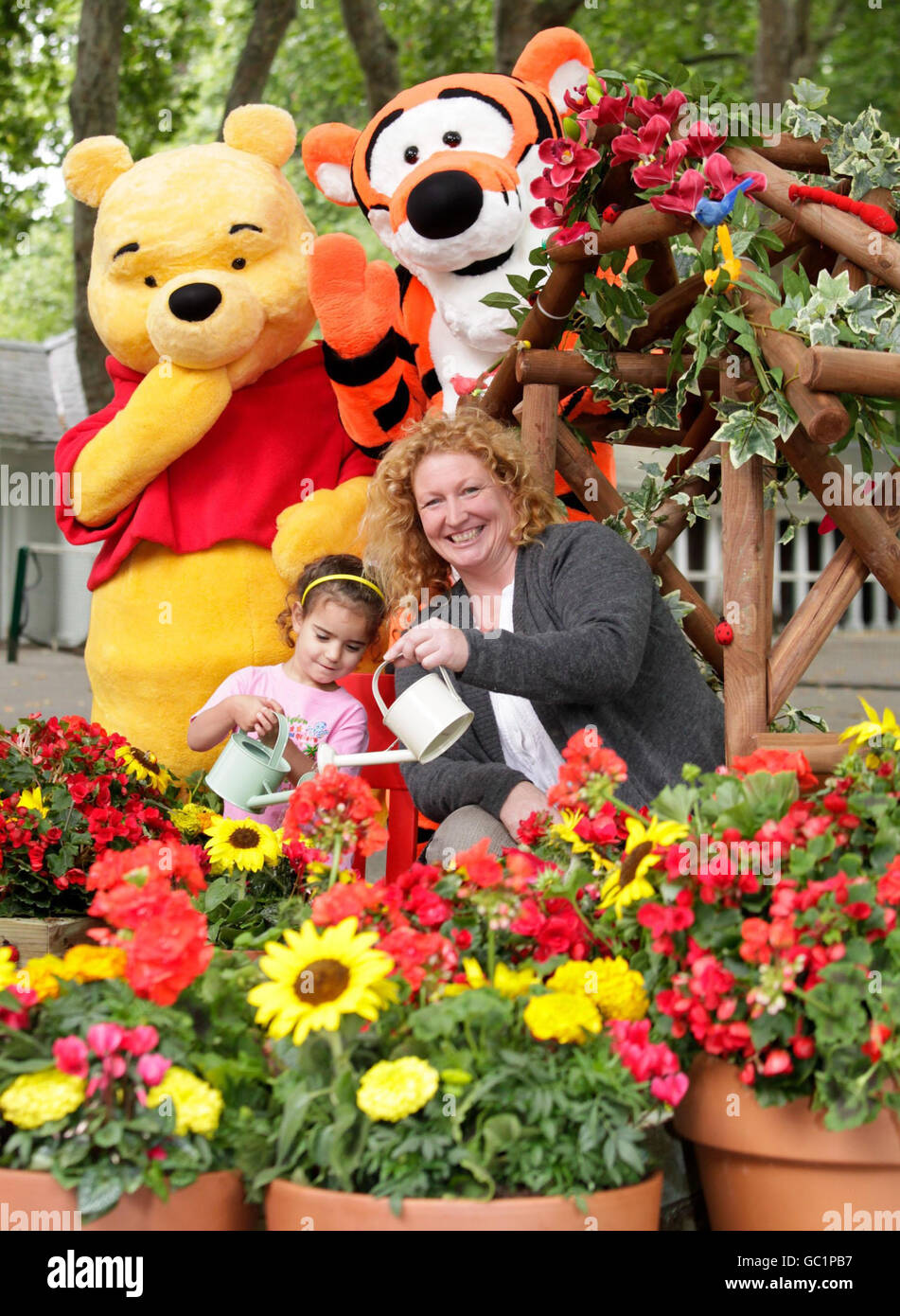 Television gardener Charlie Dimmock, who has lent her green-fingered expertise to a Disney campaign to get children involved in gardening, meets 'Winnie-the-Pooh' and 'Tigger' at Coram's Fields in central London, with Amaya, 3, where a special garden has been created as part of the initiative. Stock Photo