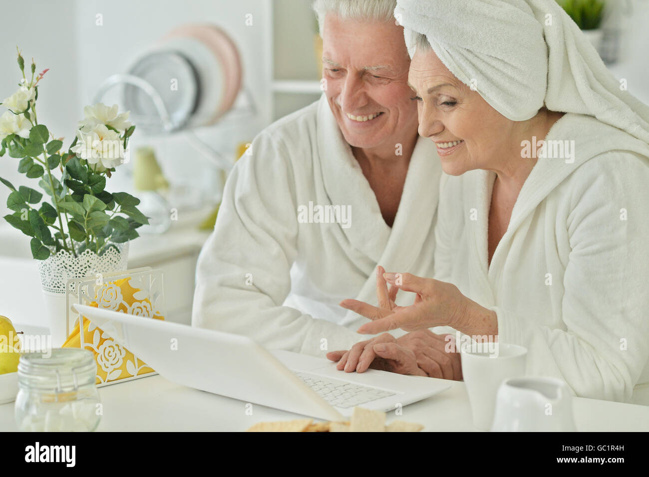 senior couple in a bathrobes with laptop Stock Photo Alamy