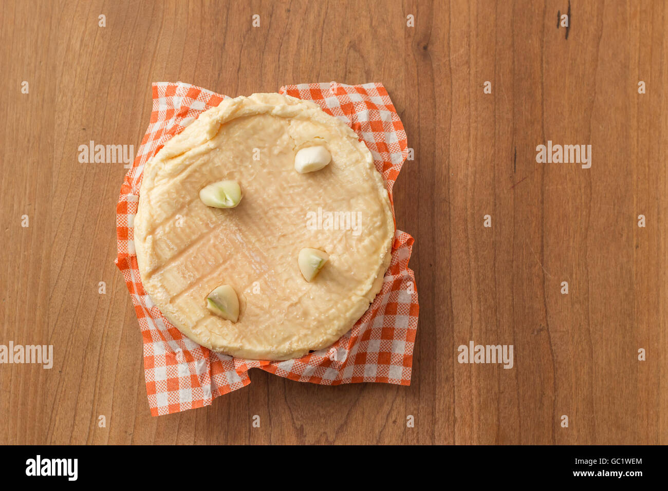 French camembert with cloves of garlic on a wooden table Stock Photo