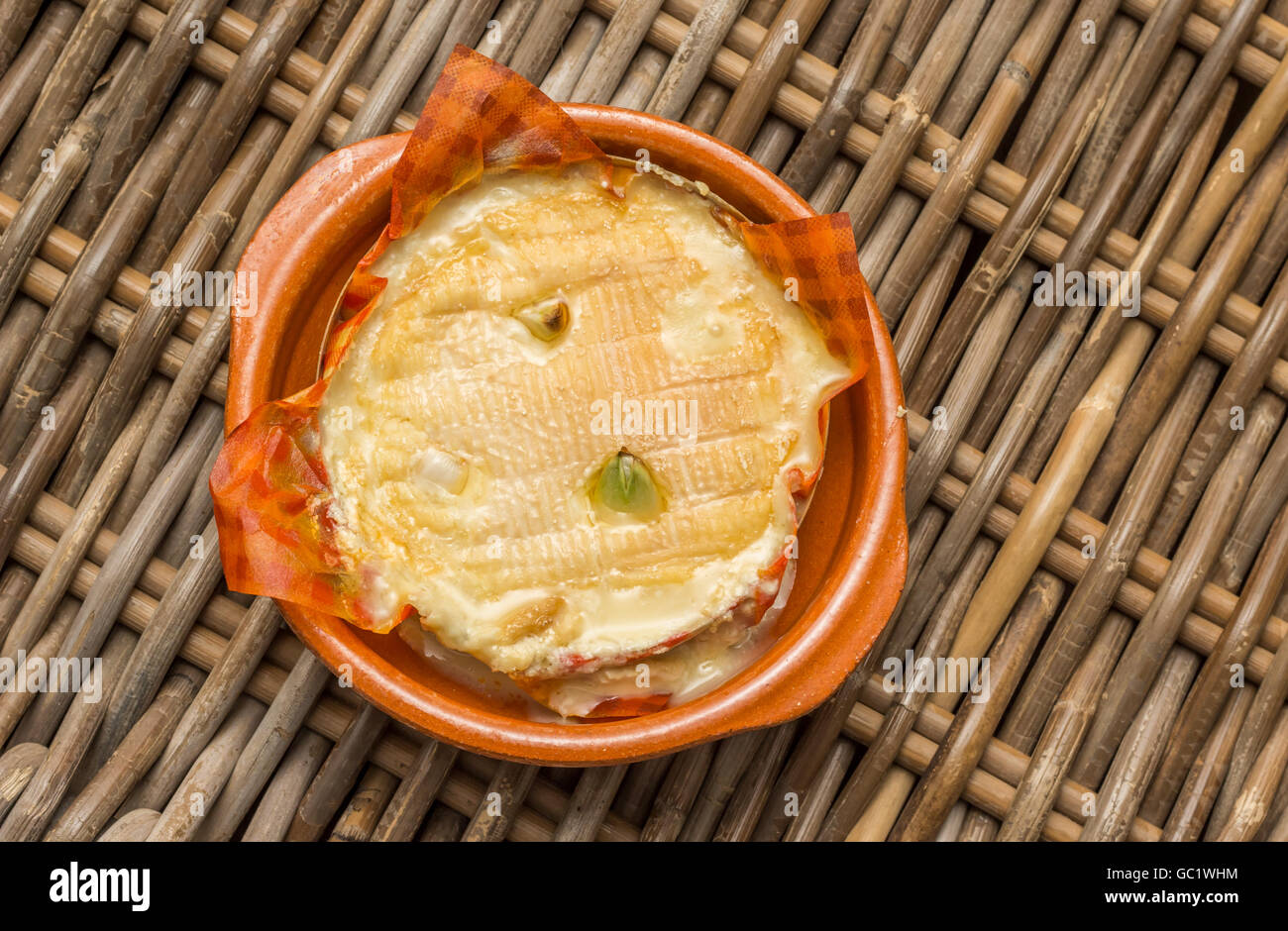 French camembert baked with cloves of garlic Stock Photo