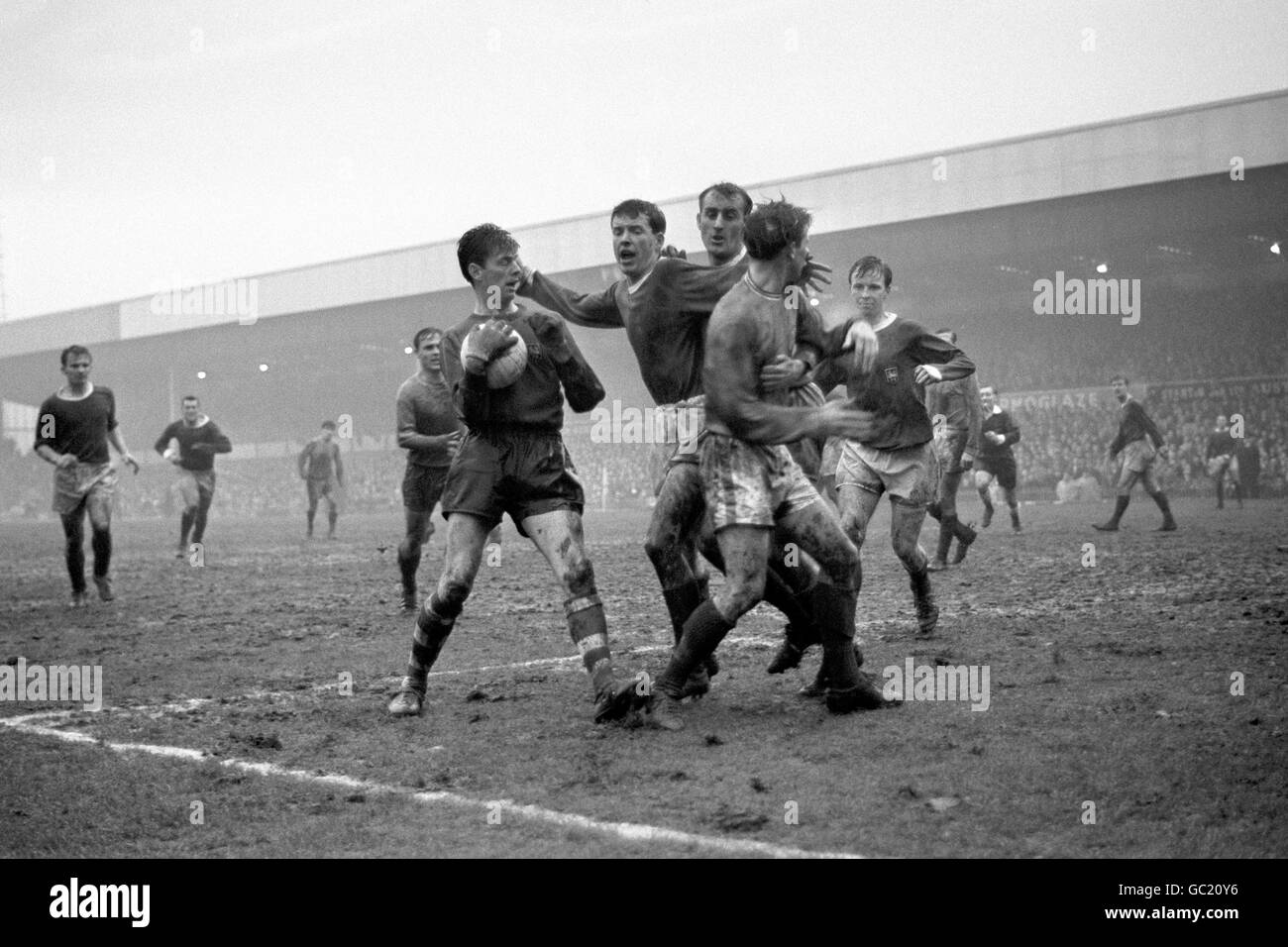 Alan Kelly, the Preston goalkeeper (holding ball, left) having been charged by Eddie Thomas, the Swansea centre forward (right, foreground). The players in centre keeping the players apart are David Wilson and Alec Ashworth, both of Preston. In right background is Nobby Lawton, the Preston captain. Stock Photo
