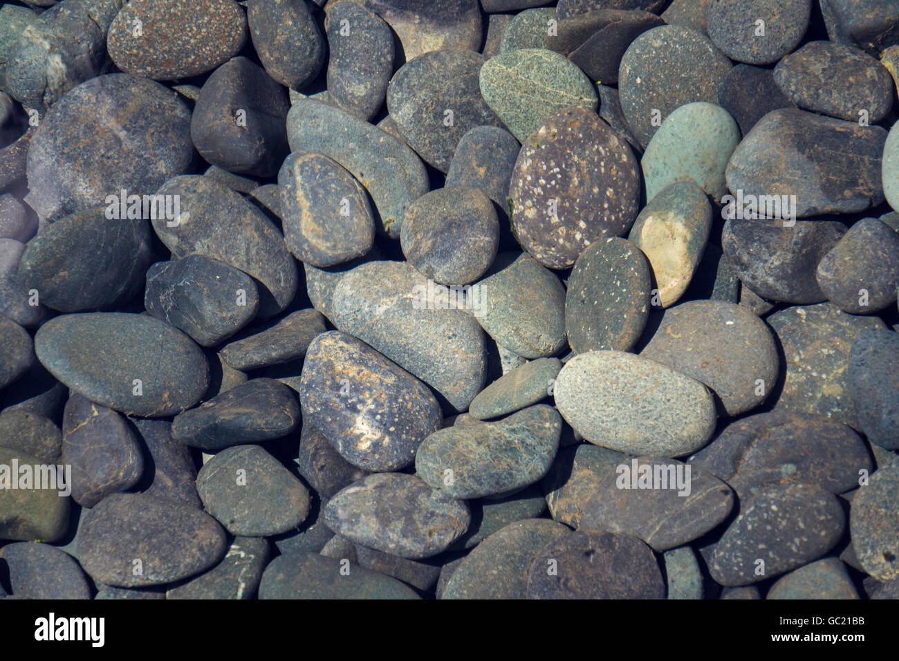 Picture full of stone pebbles under water lake bed background Stock