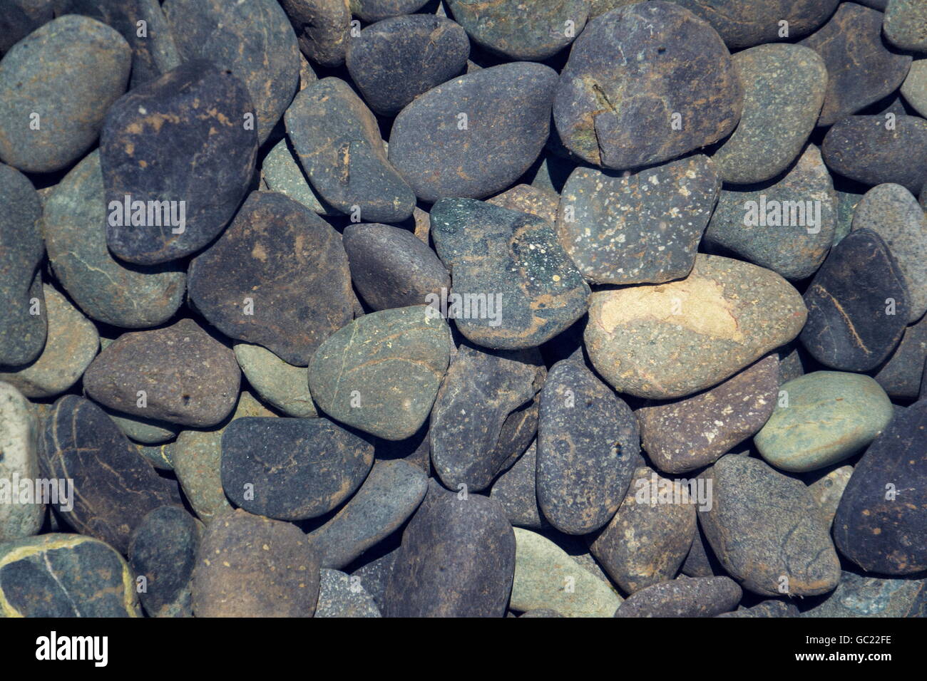 Picture full of stone pebbles under water lake bed background Stock