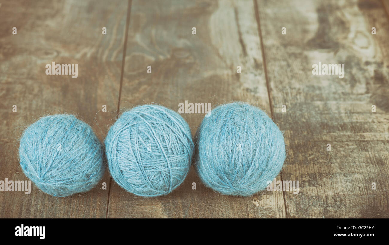 Retro stylized three yarn balls on a wooden background. Stock Photo