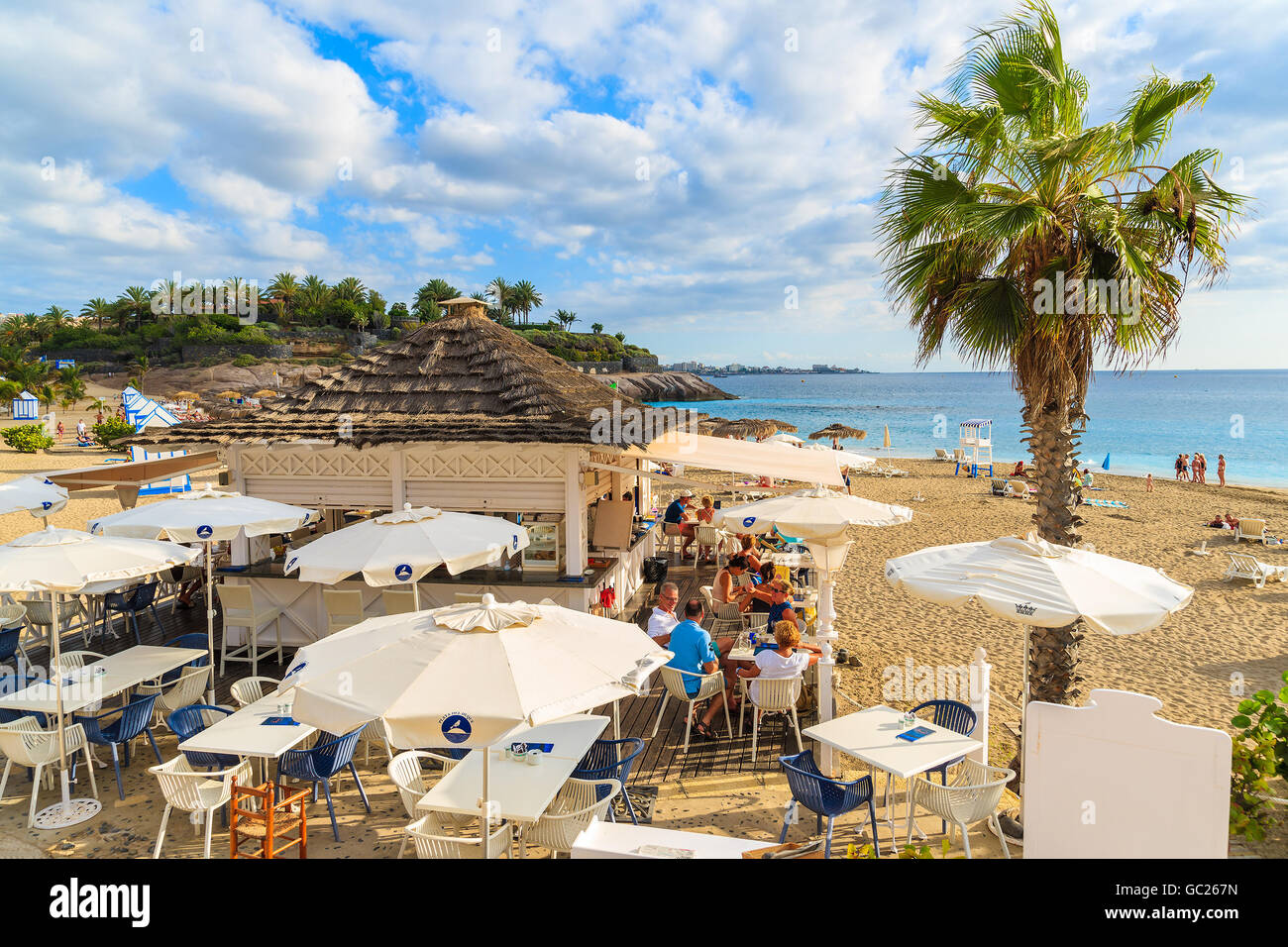 EL DUQUE BEACH, TENERIFE ISLAND - NOV 17, 2015: people sitting in a restaurant building on El Duque beach in Costa Adeje town, T Stock Photo