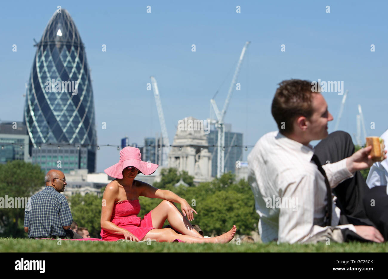 People sit in the sun in Potters Field Park, London, as the South East basks in the wake of a Continental heat wave. Stock Photo