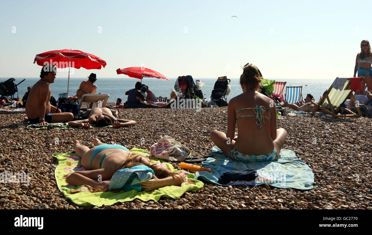 People sunbathe on Brighton beach in East Sussex, as the warm weather continues. Stock Photo