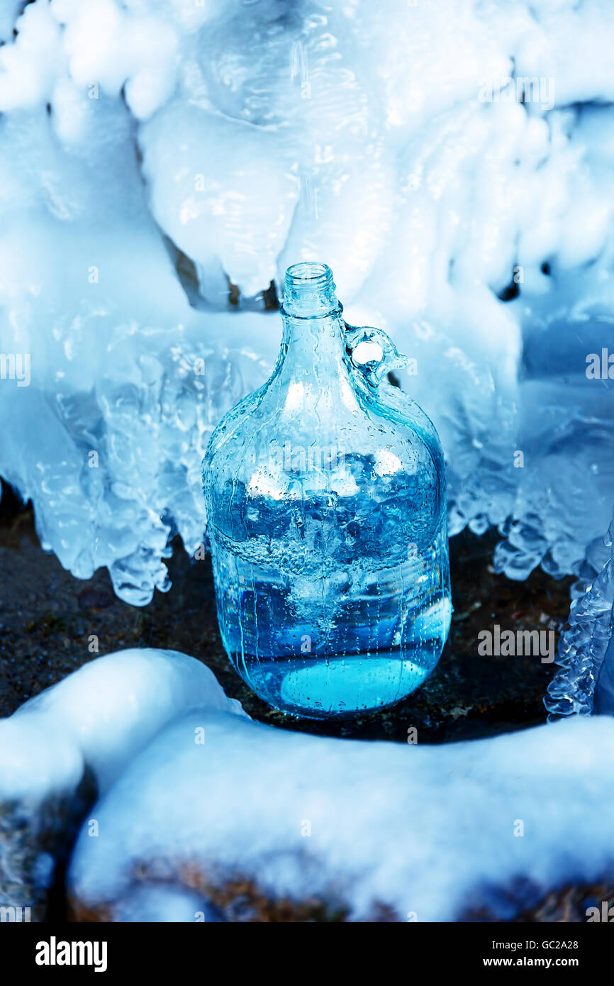 glass bottle with beautiful frozen winter spring. Stock Photo