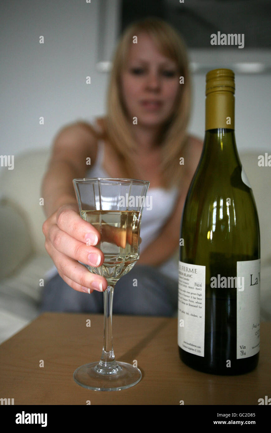 PICTURE POSED BY MODEL A woman reaches for a glass of white wine Stock ...