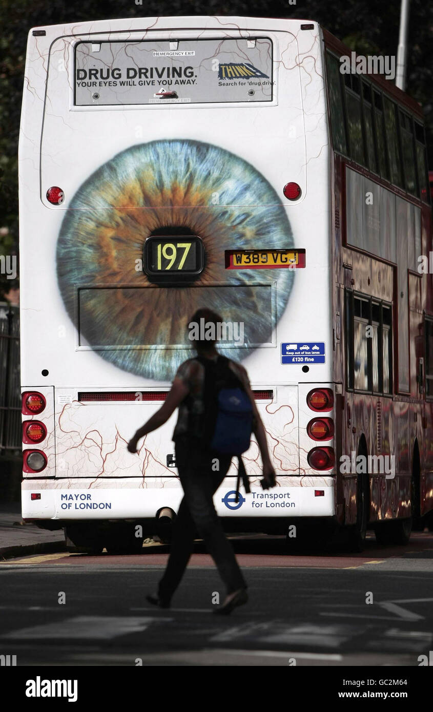 A woman crosses the road behind a bus displaying Transport for London's