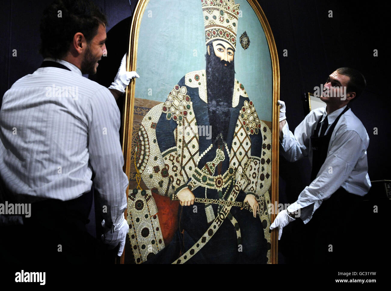 Sotheby's technicians in London handle a portrait of Iranian monarch Fath 'Ali Shah Qajar, estimated at250,000 to 350,000 at the auctioneer's sale Arts of the Islamic World, which is to take place on October 7. Stock Photo