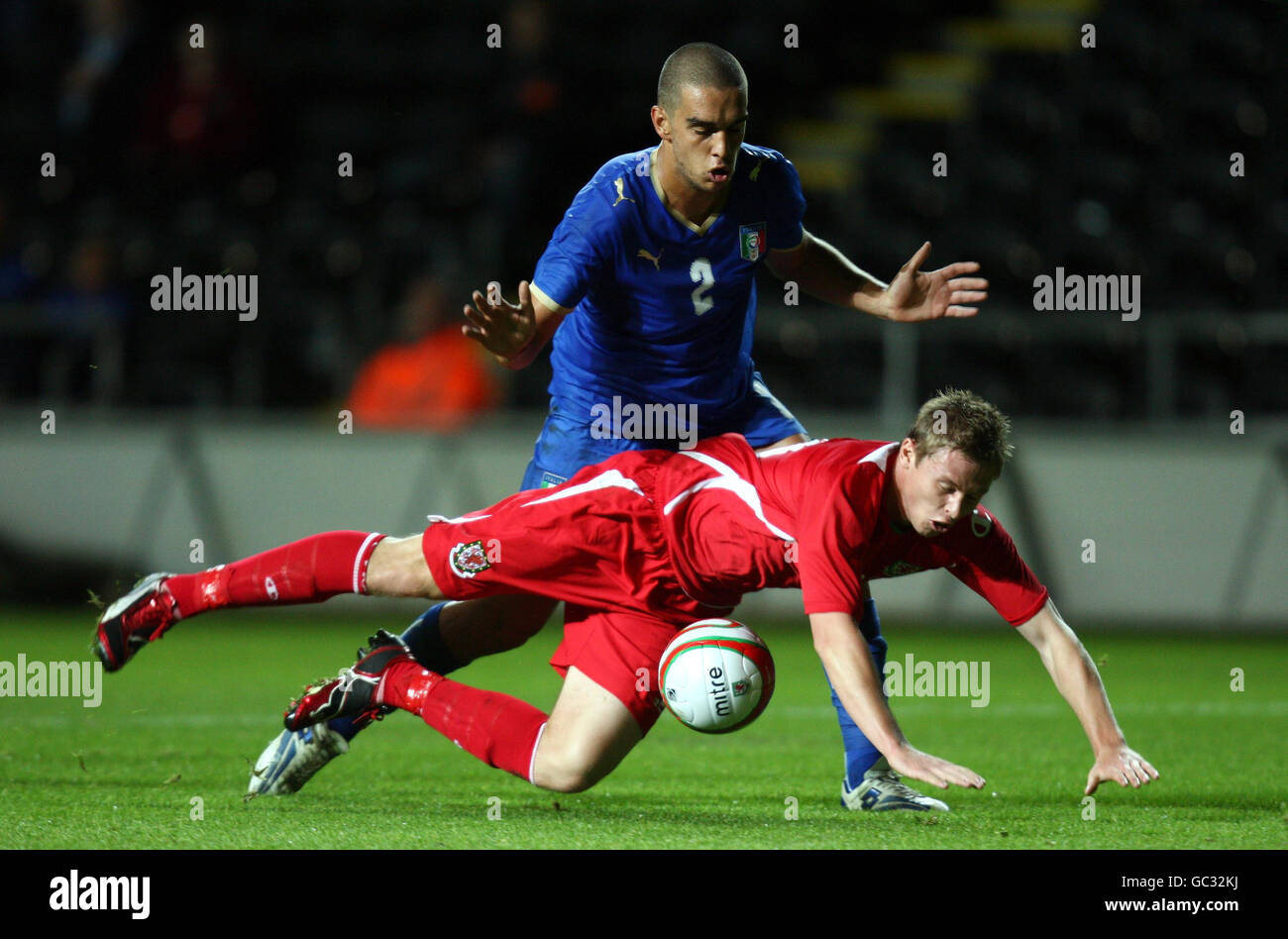 Wales' Simon Church (floor) goes down under the challenge of Italy's Giuseppe Bellusci during the UEFA Under 21 Qualifying match at the Liberty Stadium, Swansea . Stock Photo