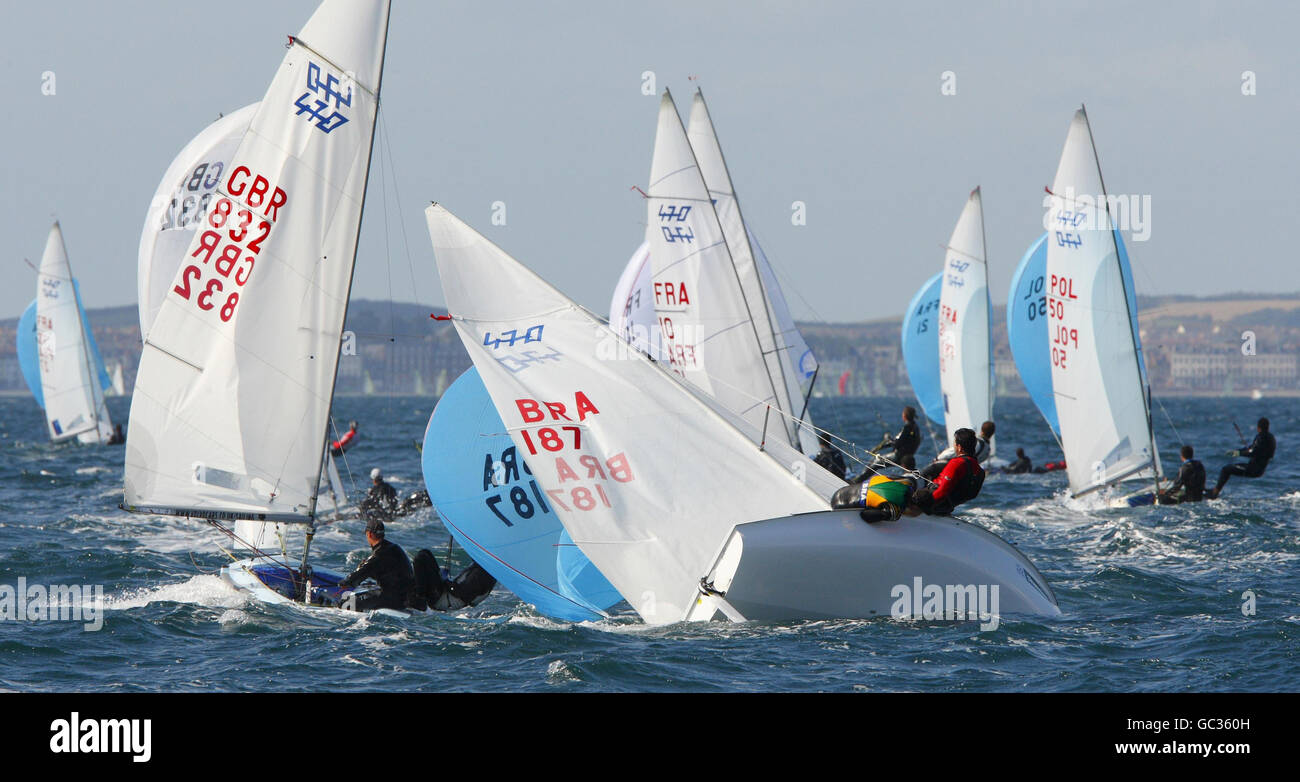 The British pair of James Ellis and Daniel Schieber (GBR832) race away as the Brazilian team of Fabio Pillar and Gustavo Thiessen capsize just behind them in the 470 class during the Skandia Sail for Gold Regatta on the English Channel. Stock Photo