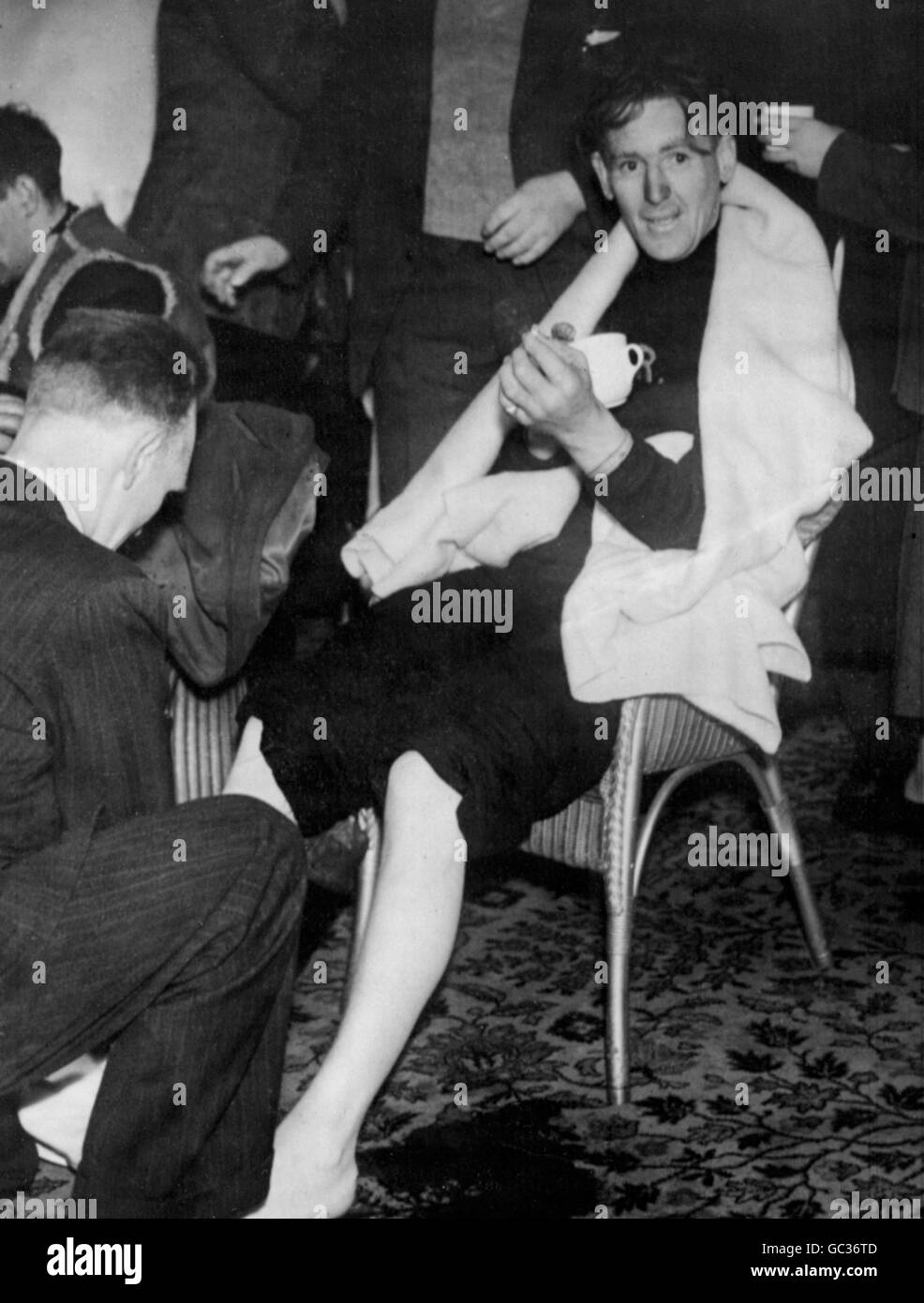 Able Seaman Malcolm McKInnon, survivor of the sunken Starnraer to Larne ferry MV Princess Victoria, has his feet massaged to warm them up on landing in Northern Ireland after his ordeal in the gale-lashed seas today (Saturday) Stock Photo