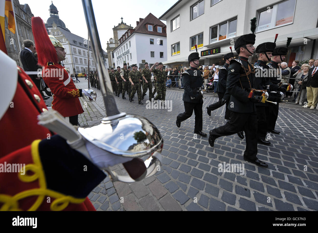Soldiers from 5 Rifles march past Quater Guards, dressed in red tunics ...