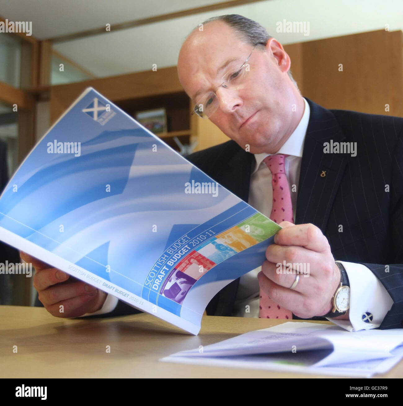 Finance Secretary John Swinney holds a copy of the Scottish Draft Budget 2010 2011 in his office in the Scottish Parliament, Edinburgh, ahead of the budget announcement later today. Stock Photo