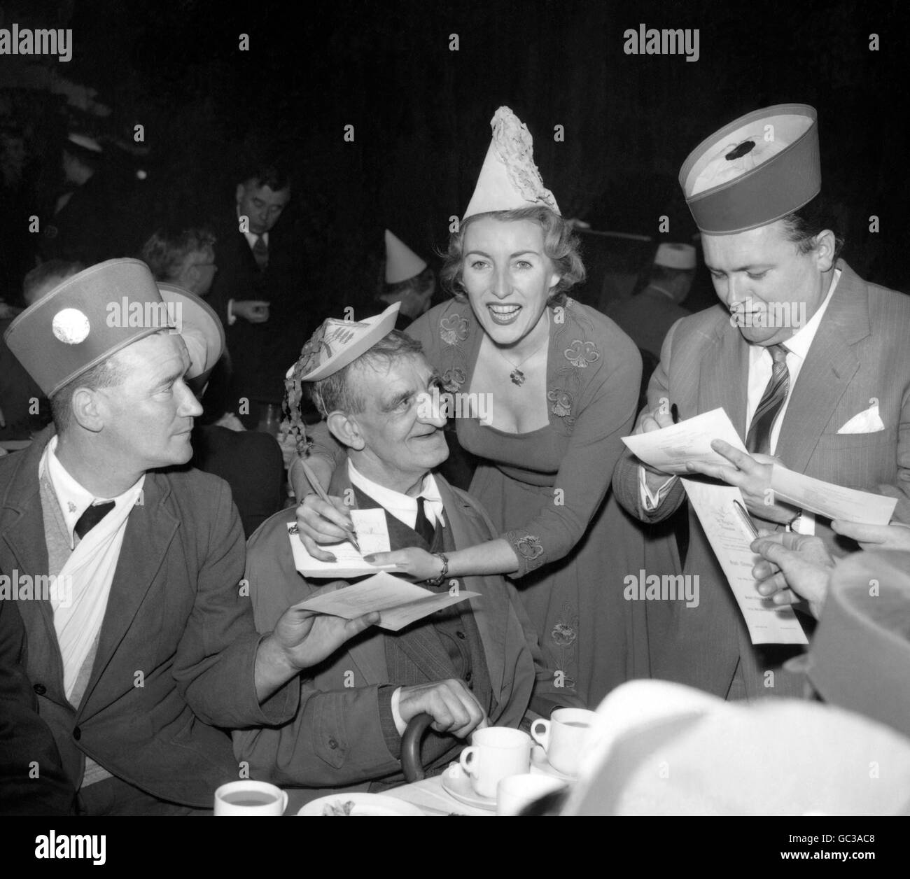 Singer Vera Lynn and comedian Harry Secombe, right, sign autographs at the tea tables during the 'Not Forgotten' Association annual Christmas party, at the Royal Riding School, Buckingham Palace. Stock Photo