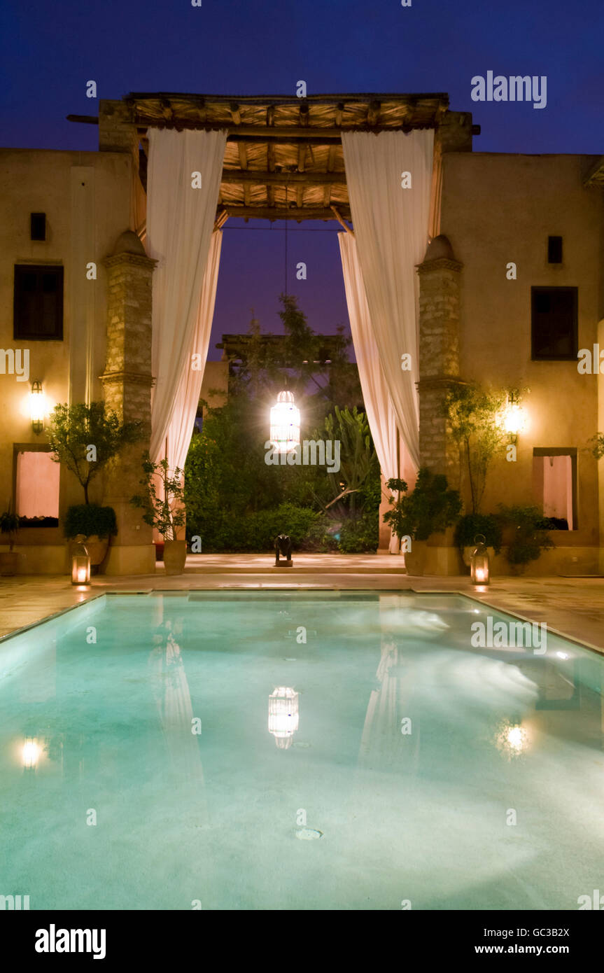 Traditionally restored Riad Caravanserai, central courtyard view at dusk, swimming pool, Marrakesh, Morocco, Africa Stock Photo