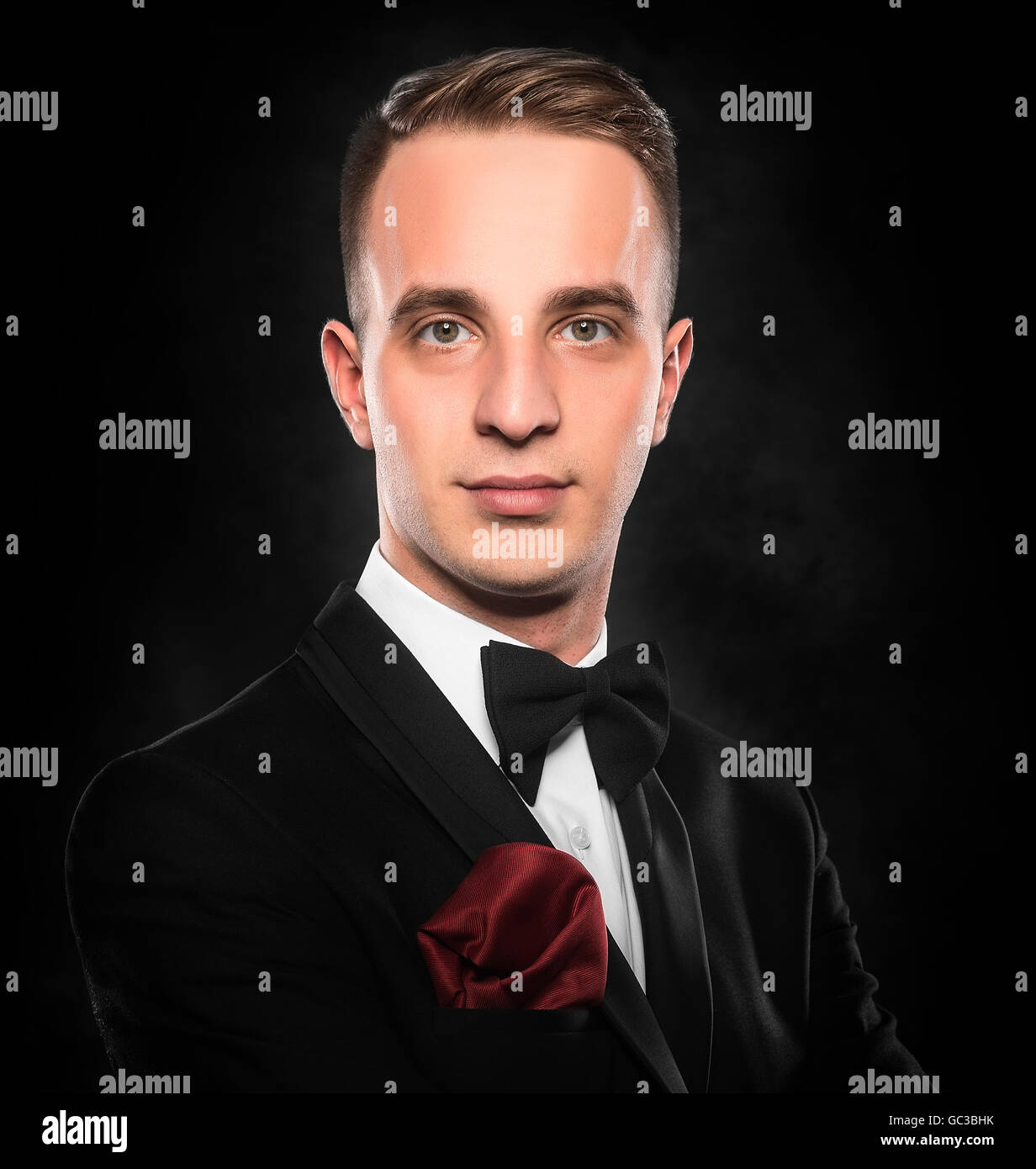 Young handsome man in black suit on dark background Stock Photo - Alamy