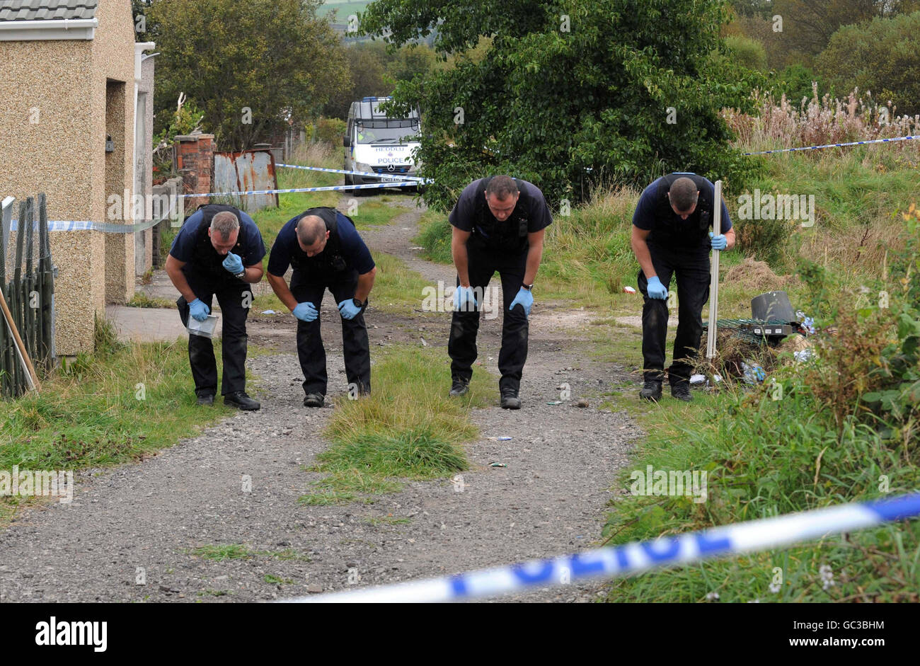 Police inspect the area in Swansea where a boy was killed in an