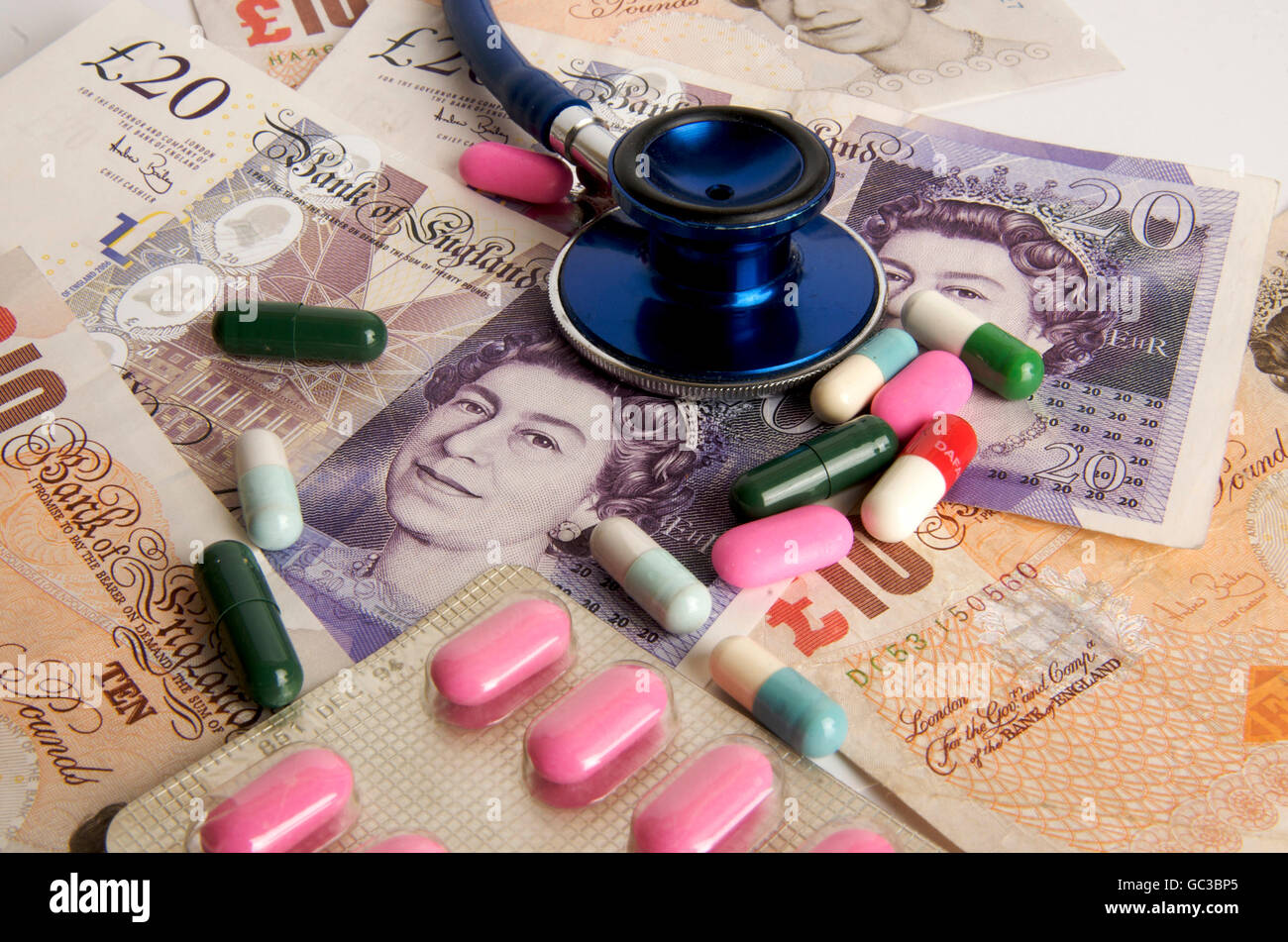 Pound sterling banknotes, stethoscope, capsules, symbolic image, health care in the United Kingdom Stock Photo