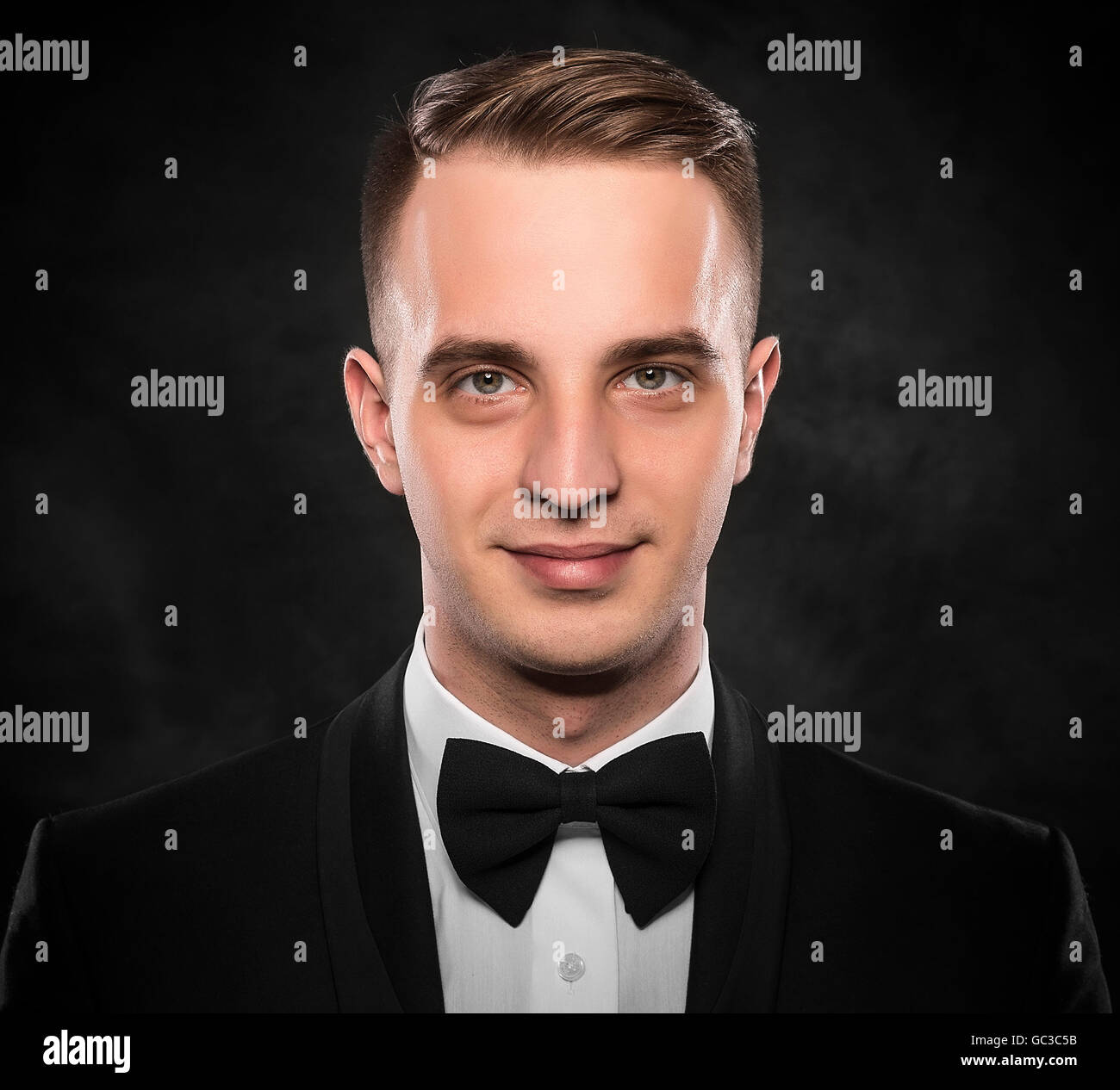 Young handsome man in black suit on dark background Stock Photo - Alamy