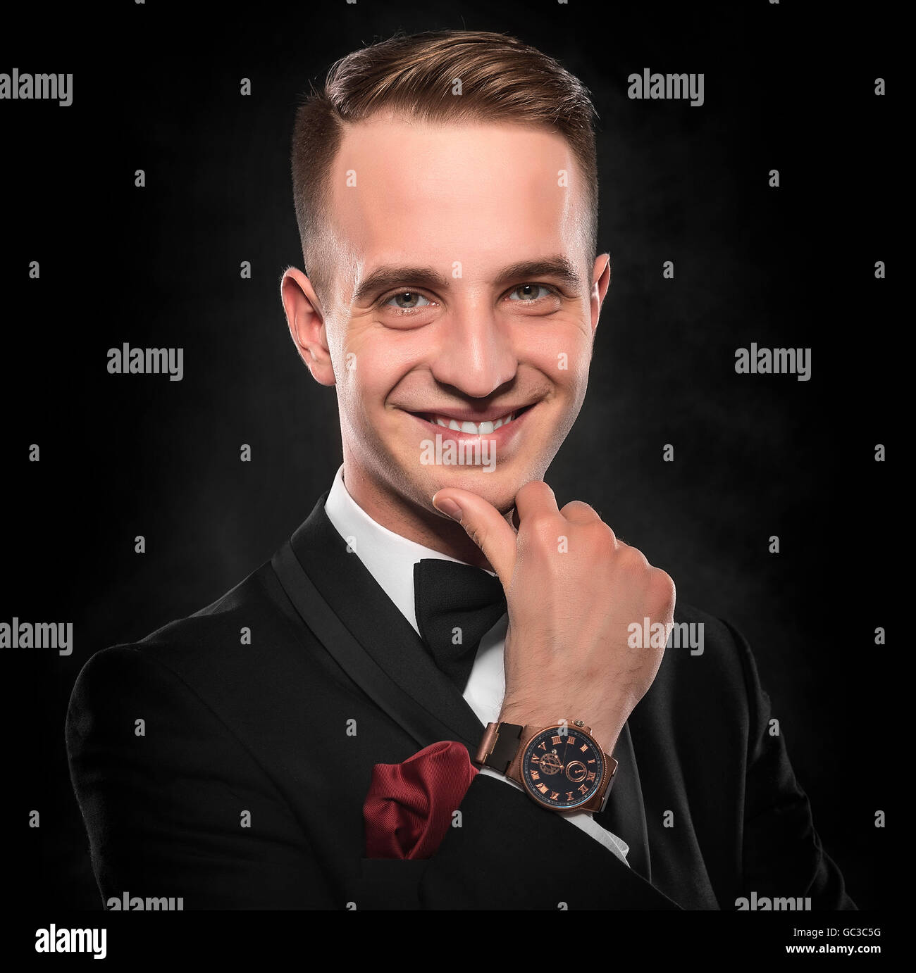 Young handsome man in black suit on dark background Stock Photo - Alamy