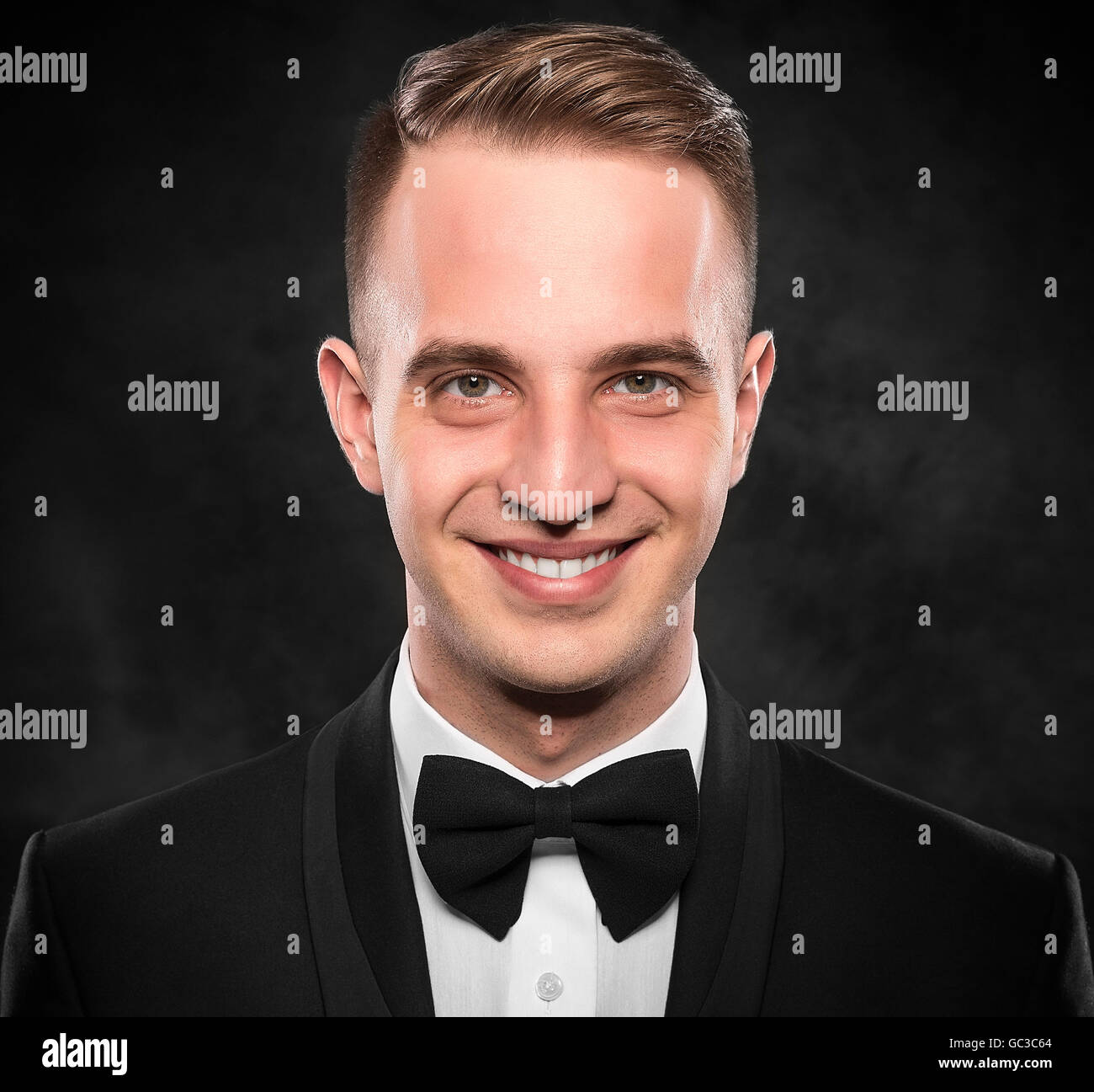 Young handsome man in black suit on dark background Stock Photo - Alamy