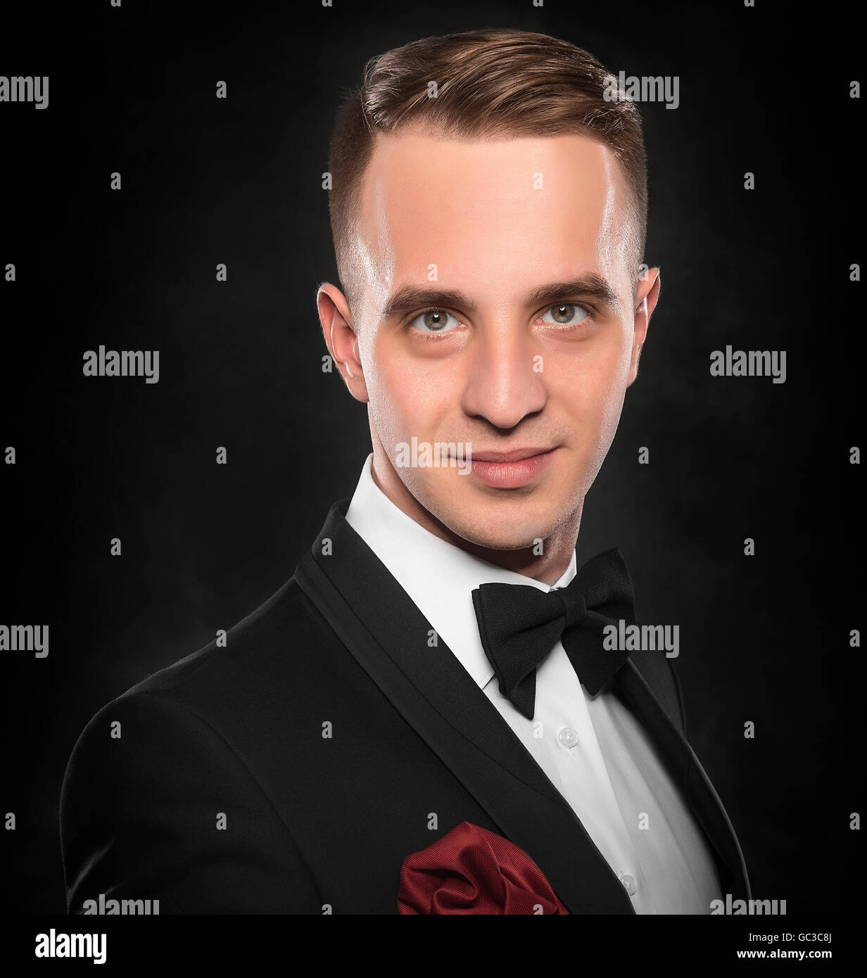 Young handsome man in black suit on dark background Stock Photo - Alamy