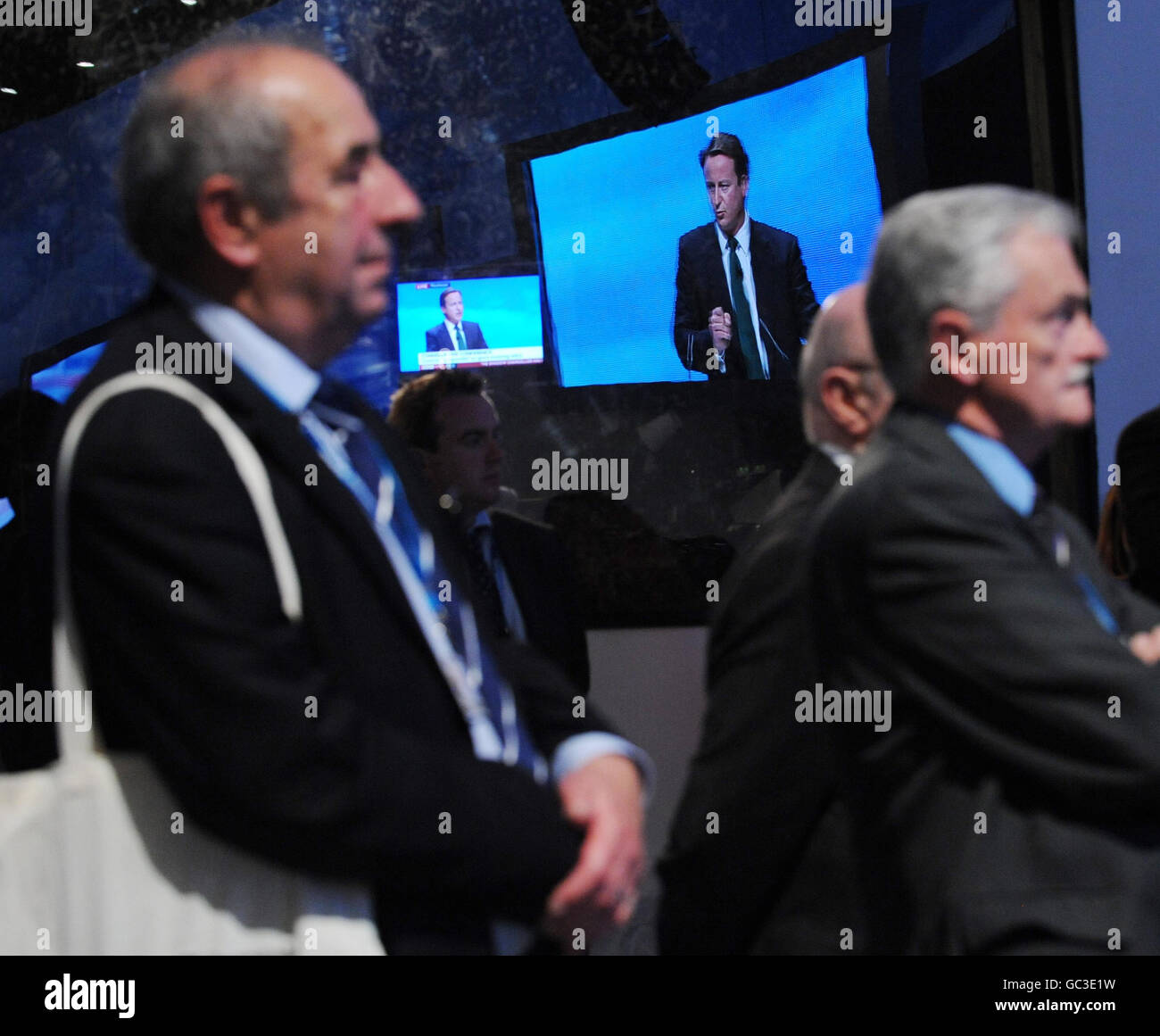 Delegates watch Tory leader David Cameron address the Conservative