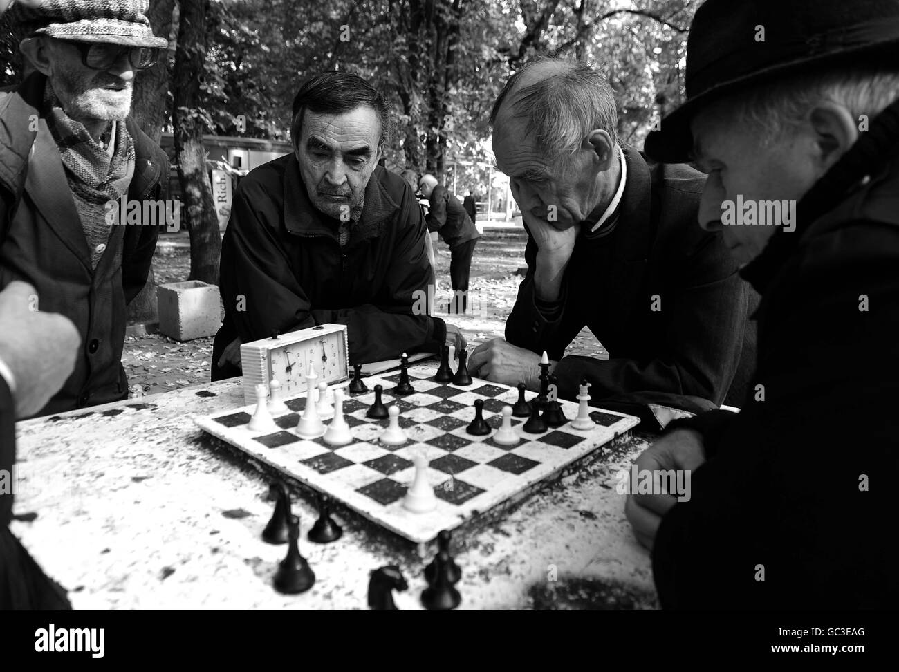 PICTURE CHANGED TO BLACK AND WHITE Men enjoy the the autumn sunshine in