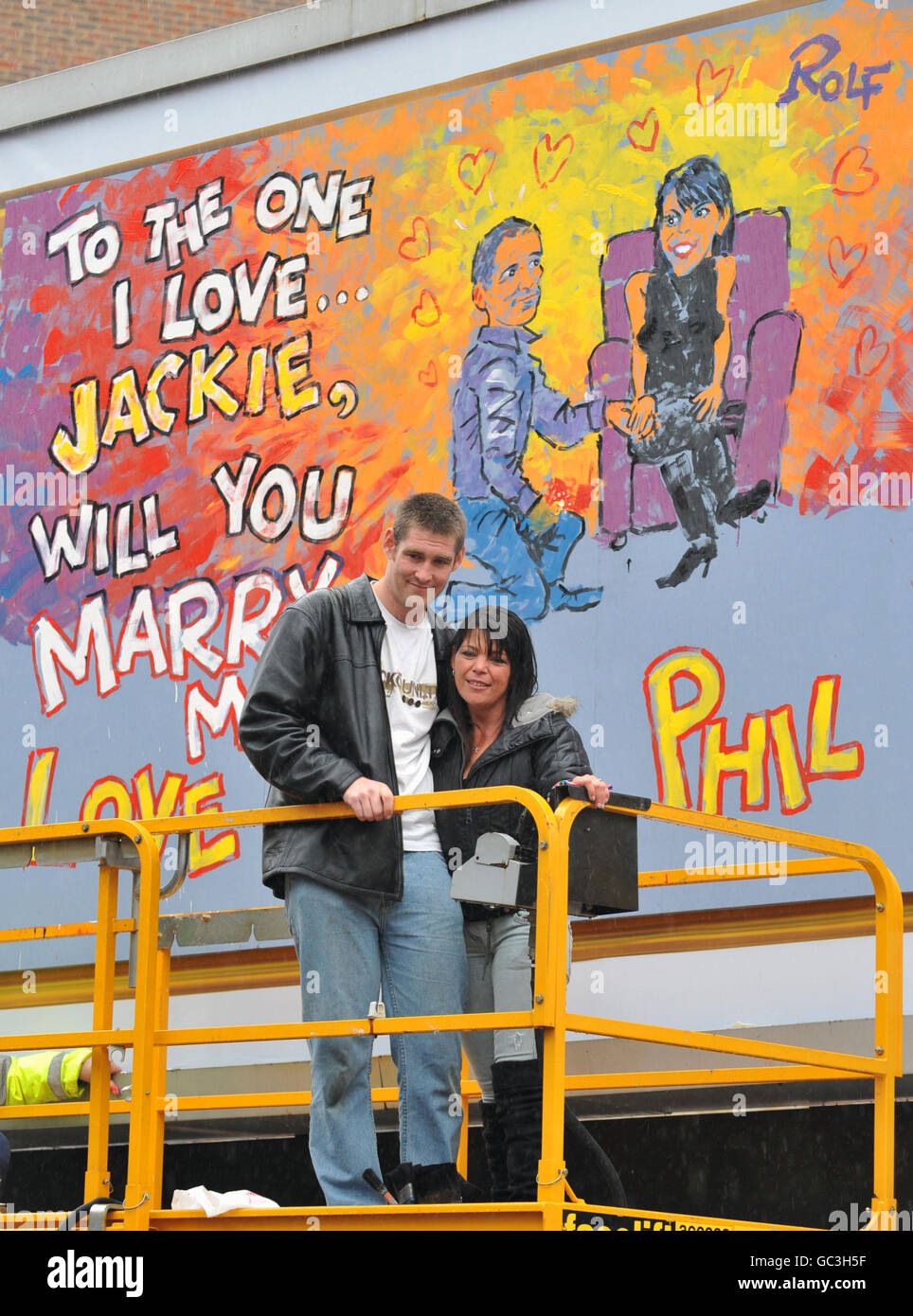 Phil Lee, from Suffolk, proposes to girlfriend Jackie Howarth with a billboard painted by Rolf Harris as part of a campaign by Cadbury's to promote Wispa Gold chocolate. Stock Photo