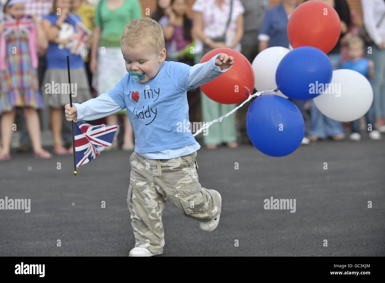 Young Luke Crouch aged 18 months wears his 'I love my daddy' t-shirt and shows his national pride with balloons and the Union flag as he waits for his dad Corporal Jonathan Crouch as 33 Armoured Engineer Squadron, 26 Engineer Regiment arrive home at Swindon Barracks in Tidworth from their tour in Afghanistan. Stock Photo