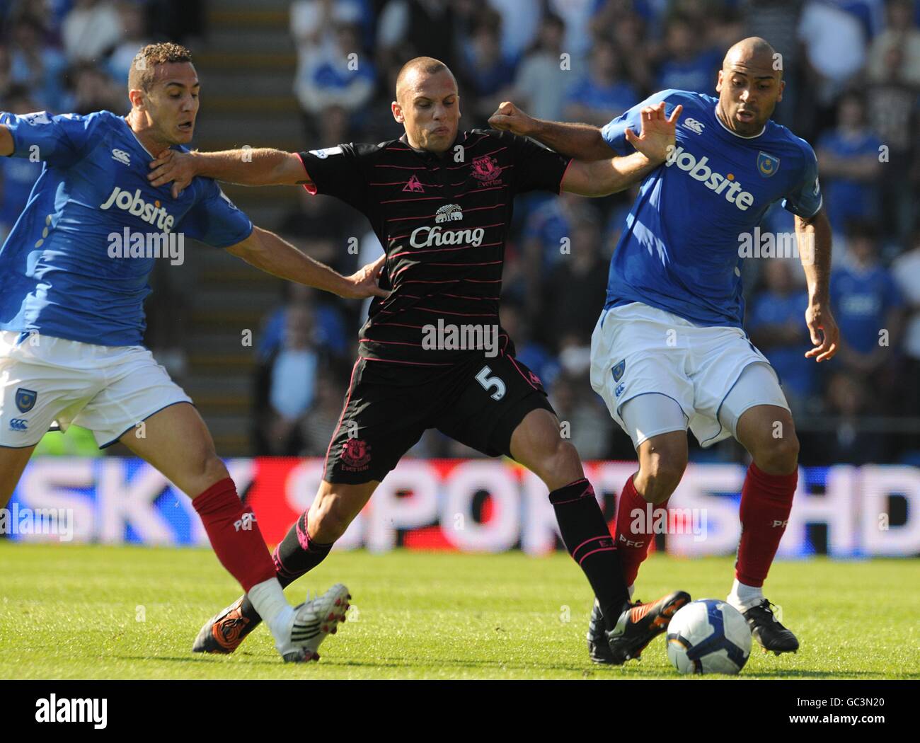 Everton's Johnny Heitinga holds off Portsmouth's Hassan Yebda (left) and Anthony Vanden Borre (right) Stock Photo