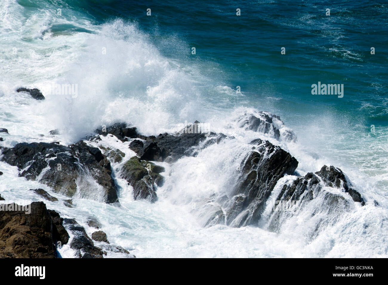 Large surf breaking on rocks Cape Byron NSW Australia Stock Photo