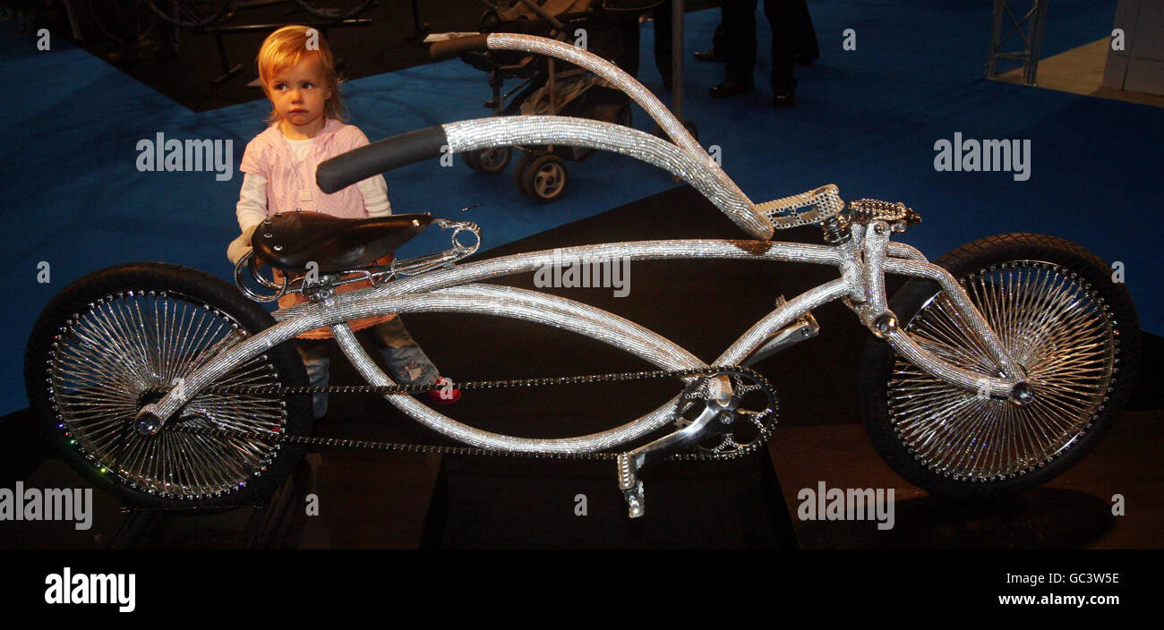 Jasmine Faulkner-Wybrott, 2, looks at a Crystal Low Rider bike by Ben Wilson, tho most expensive bike ever made in the UK with over 110 thousand crystals, at the cycle show at Earls Court, London. Stock Photo
