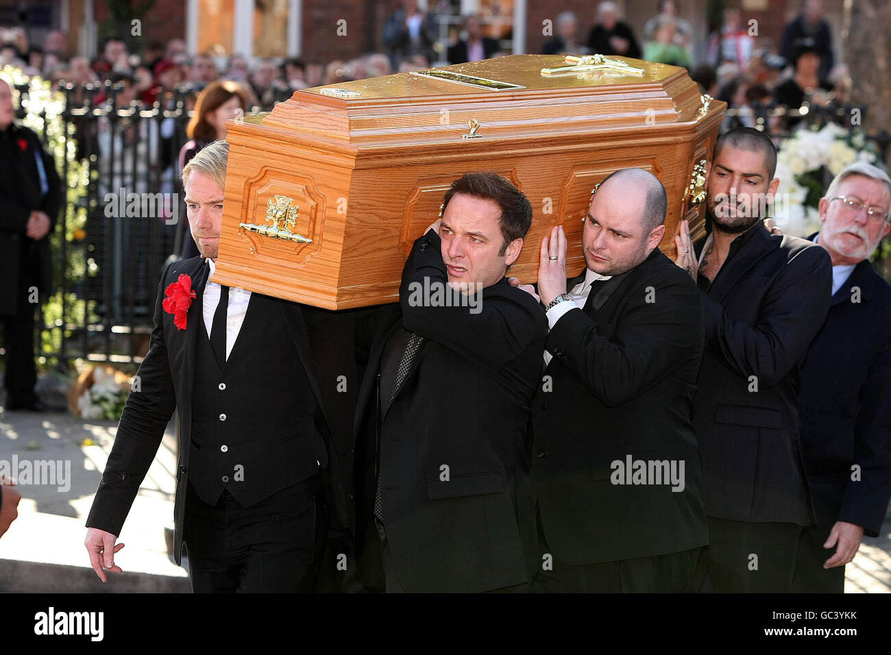 Boyzone members Ronan Keating (front left), Mikey Graham (front right) and Shane Lynch (back right) carry the coffin of Stephen Gately outside St Laurence O'Toole Church in Dublin where his funeral has been taking place. Stock Photo