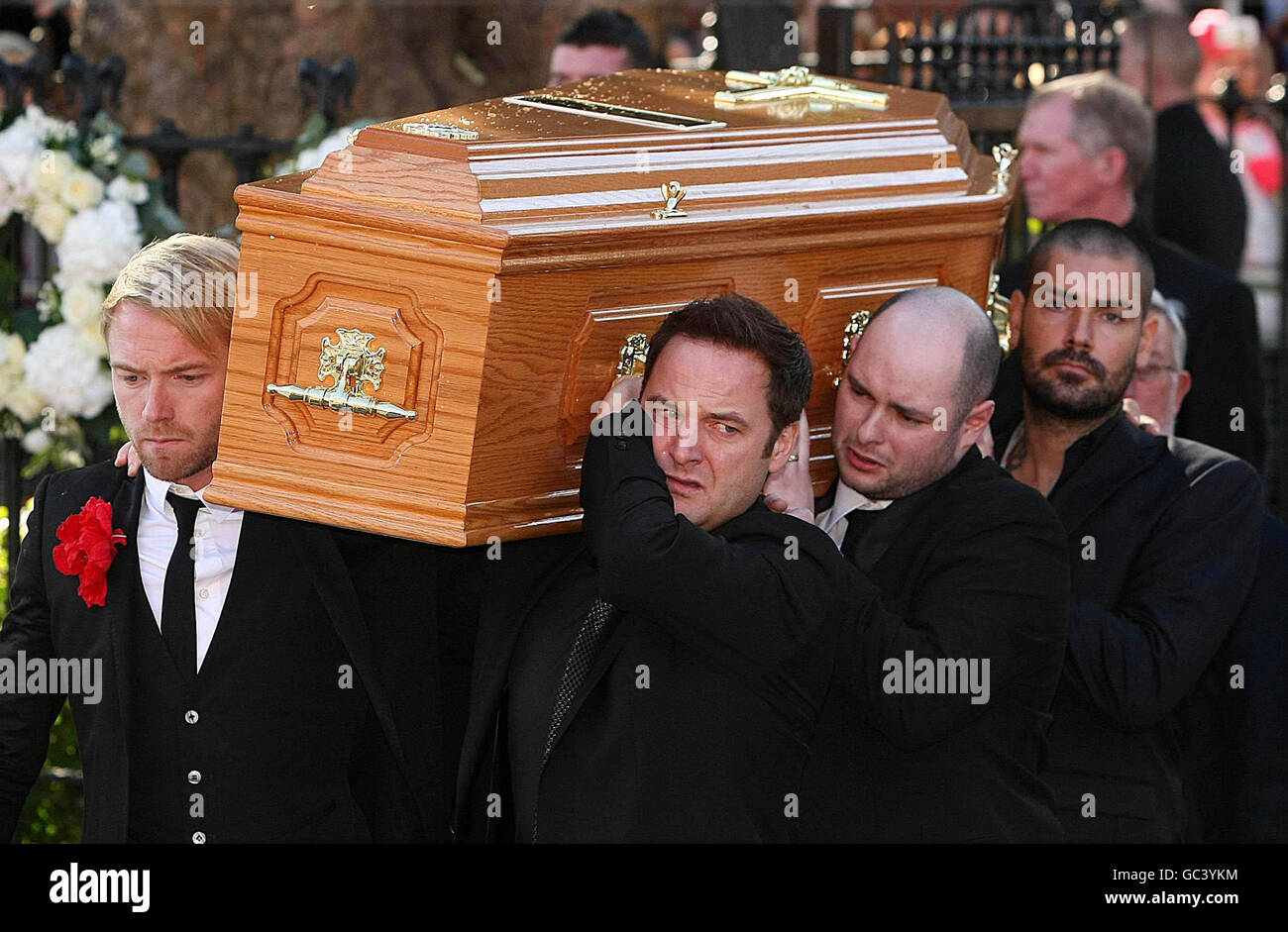 Boyzone members Ronan Keating (front left), Mikey Graham (front right) and Shane Lynch (back right) carry the coffin of Stephen Gately outside St Laurence O'Toole Church in Dublin where his funeral has been taking place. Stock Photo