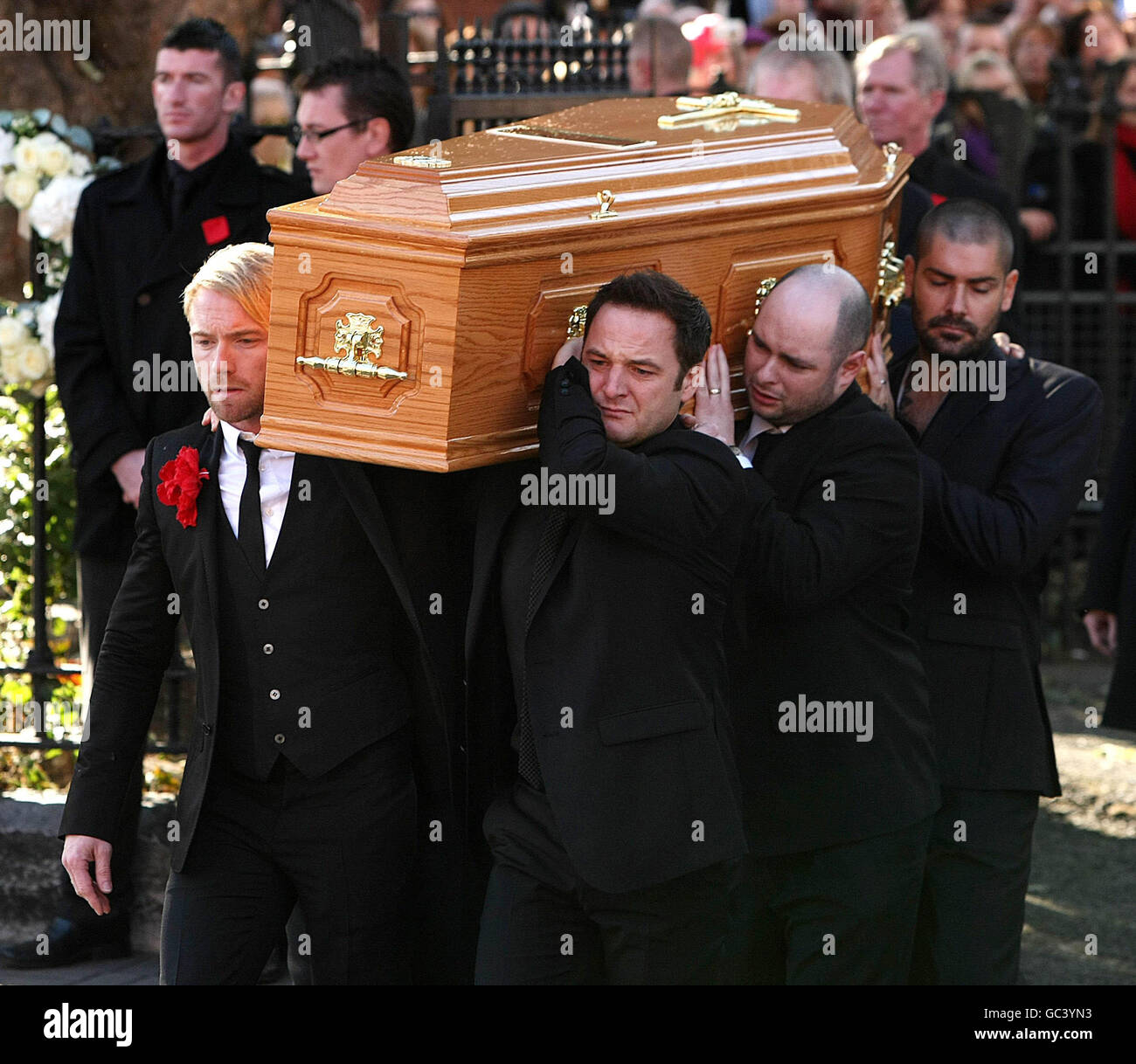 Boyzone members Ronan Keating (front left), Mikey Graham (front right) and Shane Lynch (back right) carry the coffin of Stephen Gately outside St Laurence O'Toole Church in Dublin where his funeral has been taking place. Stock Photo