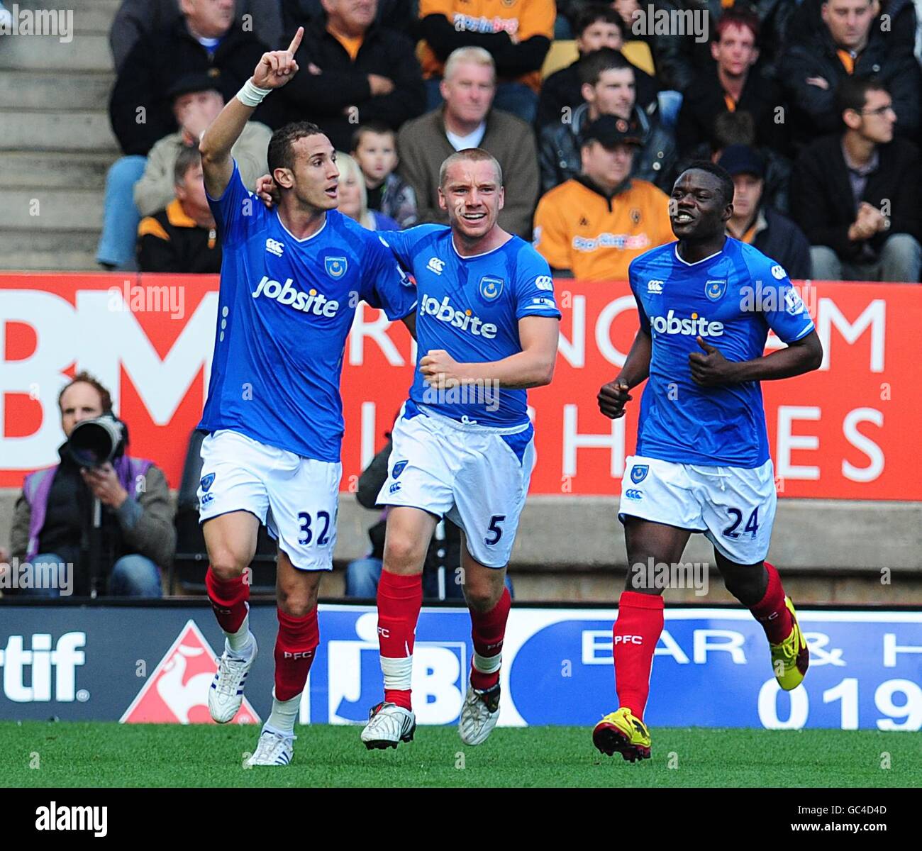 Portsmouth's Hassan Yebda (left) celebrates scoring the opening goal with team mates Jamie O'Hara (centre) and Aruna Dindane (right). Stock Photo