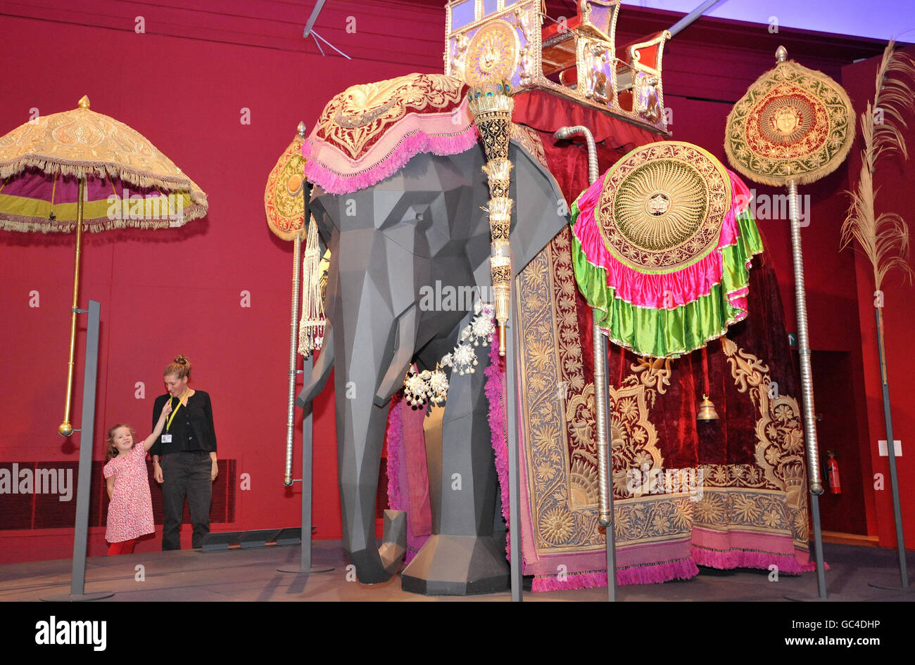 Carrie Rees shows her sister Eva, six, a model elephant adorned with animal jewellery from the royal collections of India, part of an exhibition, Maharaja: The Splendour of Indias Royal Courts, on show at the Victoria and Albert Museum, in London. Stock Photo