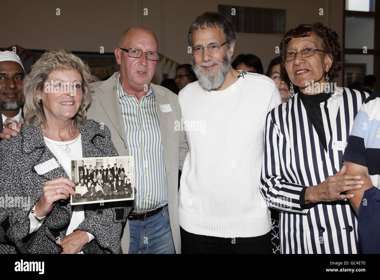 Yusuf Islam (2nd right) with one of his former teachers Yuna Simpson (right) and former school friends Janet Dowling (holding an old class photograph with a young Yusuf pictured) and John Langsworthy during his visit to his old school Hugh Myddelton Primary School. Stock Photo
